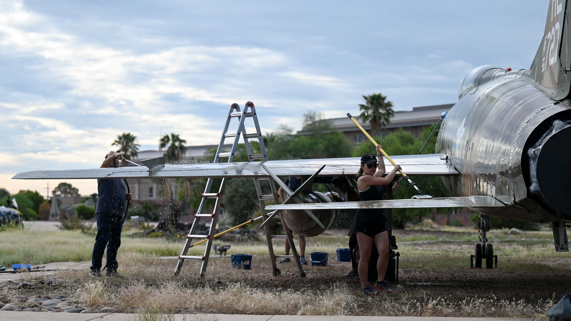 A photo of people washing a plane.