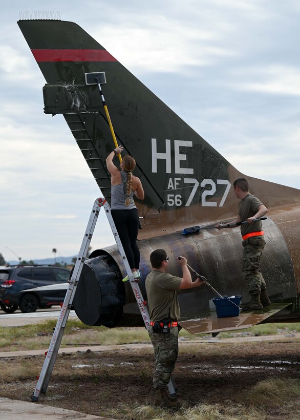 A photo of people washing a plane.