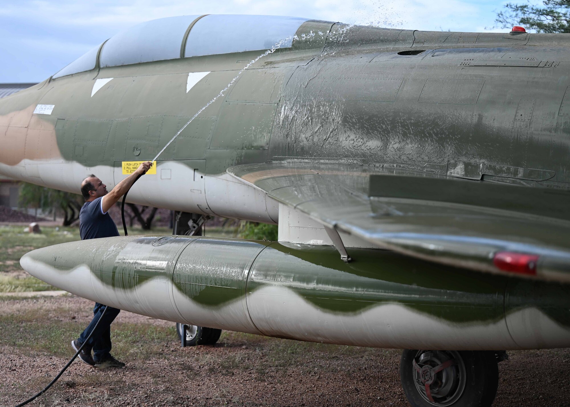 A photo of a man washing a plane.