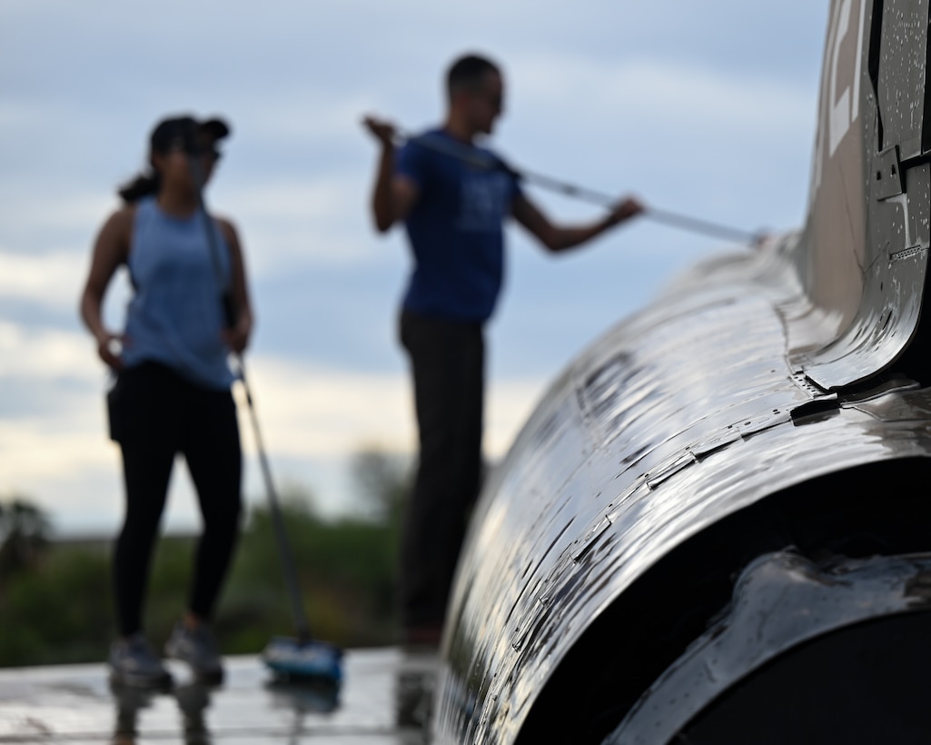 A photo of people washing a plane.