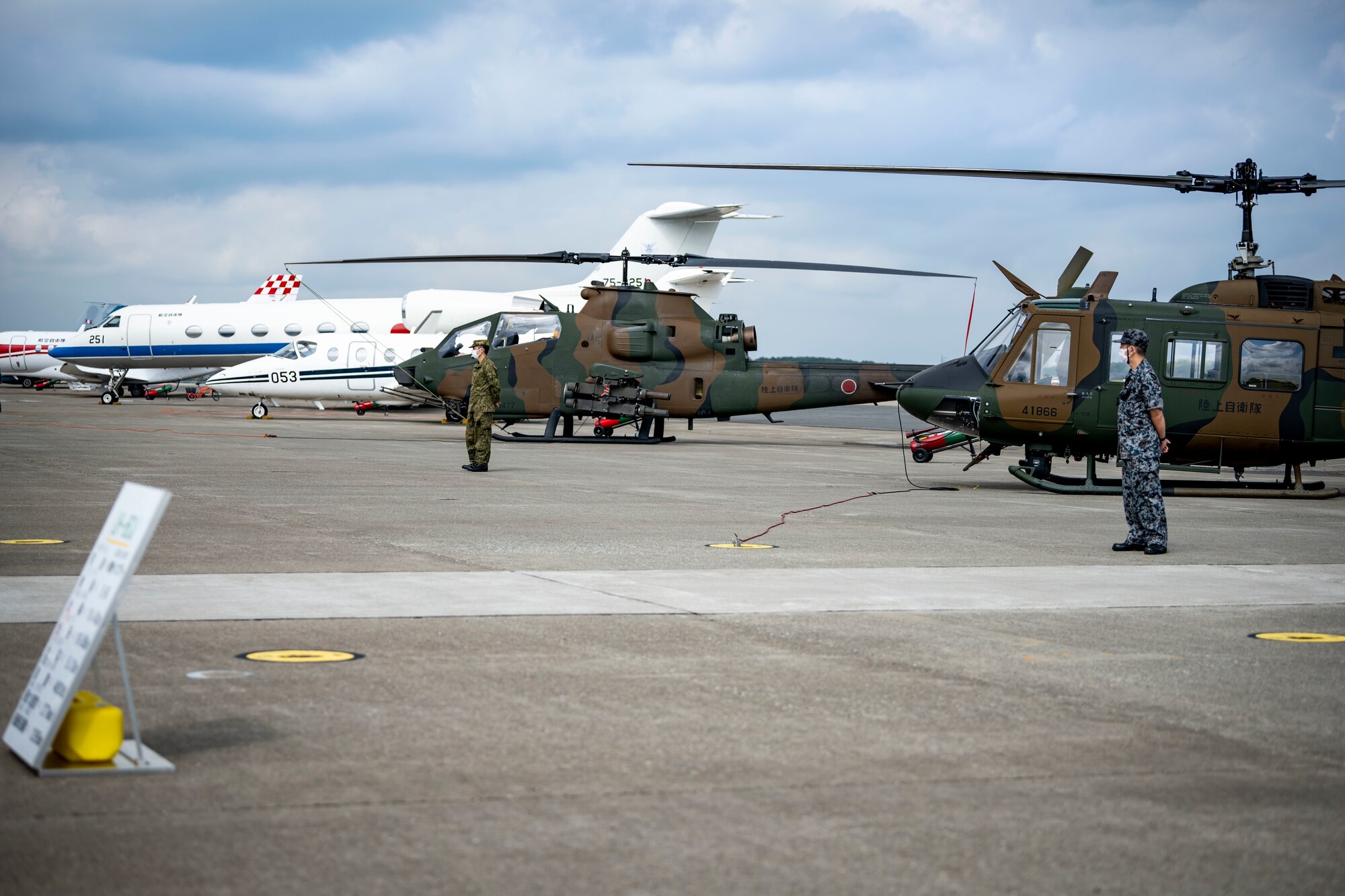 Japanese military members stand in front of an aircraft