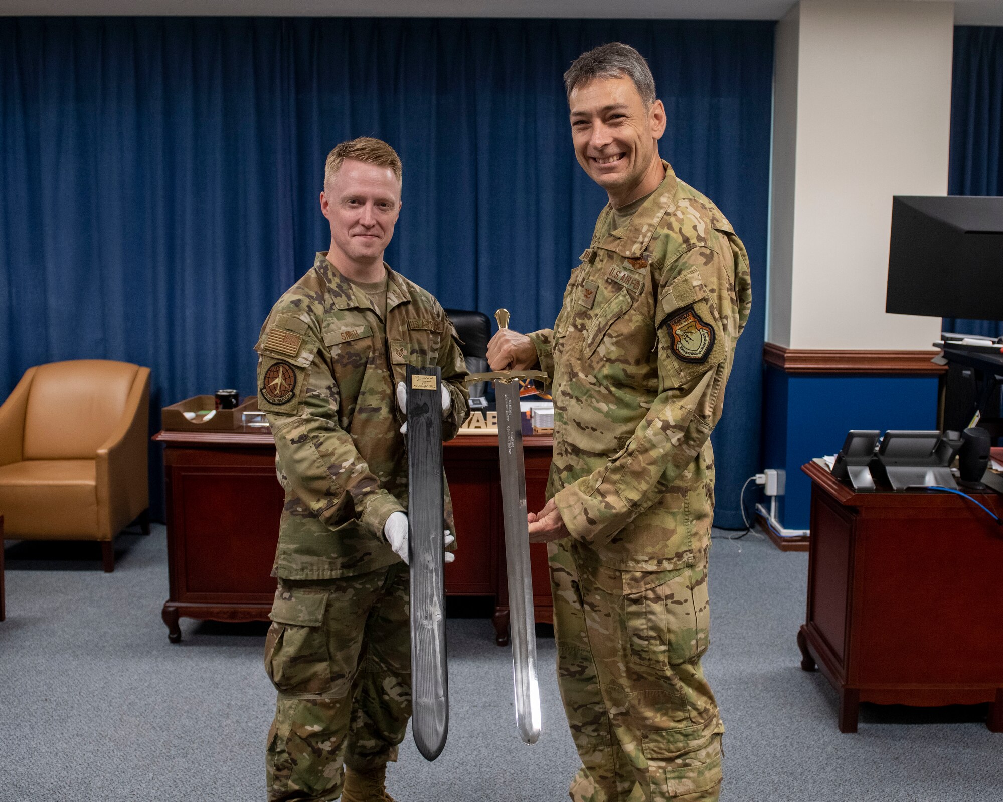 The Wing Commander stands with an Airman and the Wing Ceremonial Sword