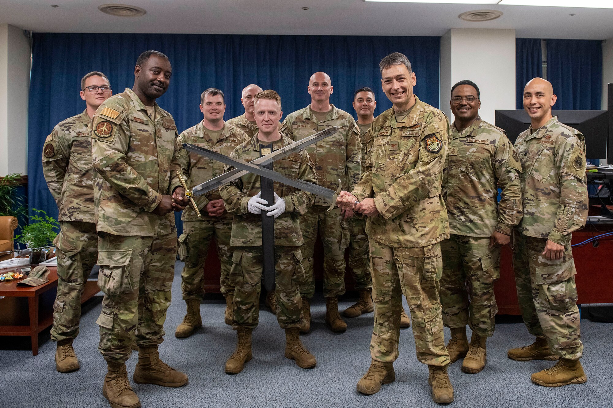 Wing leadership and Airmen from the 374th Airlift Wing stand together with the retired and newly presented Wing Ceremonial Swords