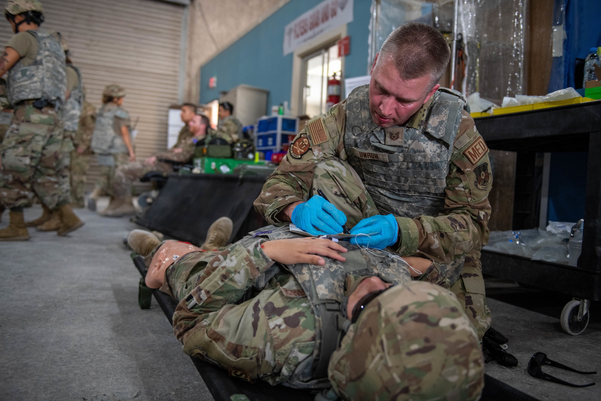 U.S. Air Force Tech. Sgt. Michael Unruh, a medic with the 379th Expeditionary Operational Medical Readiness Squadron, treats a simulated casualty during Exercise Grand Shield 22-5 on Al Udeid Air Base, Qatar, Sept. 9, 2022. Firefighters, security forces, and medical personnel participated in the exercise. (U.S. Air National Guard photo by Airman 1st Class Constantine Bambakidis)