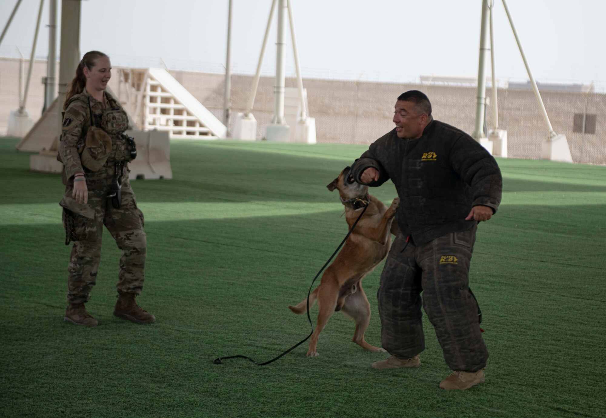 Bico, a military work dog with the 379th Expeditionary Security Forces Squadron, takes a bite out of U.S. Air Force Chief Master Sgt. Joseph Arce, 379th Air Expeditionary Wing command chief, during a K-9 demonstration Sept. 12, 2022 at Al Udeid Air Base, Qatar. The 379th ESFS held the K-9 demonstration to showcase the capabilities of its military working dogs. (U.S. Air National Guard photo by Master Sgt. Michael J. Kelly)