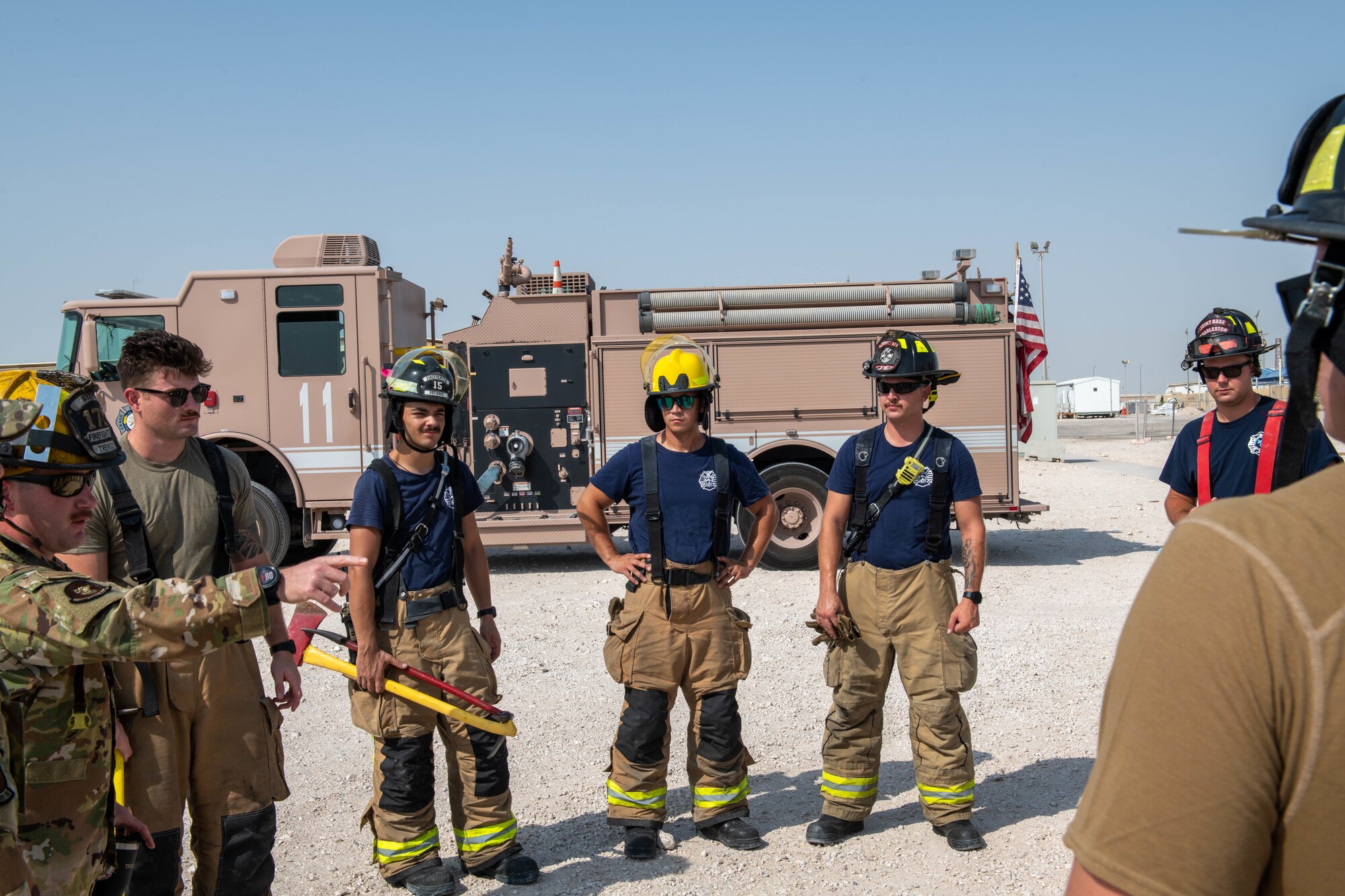 Firefighters with the 379th Expeditionary Civil Engineer Squadron prepare for a forced entry exercise on Al Udeid Air Base, Qatar, Sept. 7, 2022. The exercise made use of trailers that had been scheduled for demolition. (U.S. Air National Guard photo by Airman 1st Class Constantine Bambakidis)