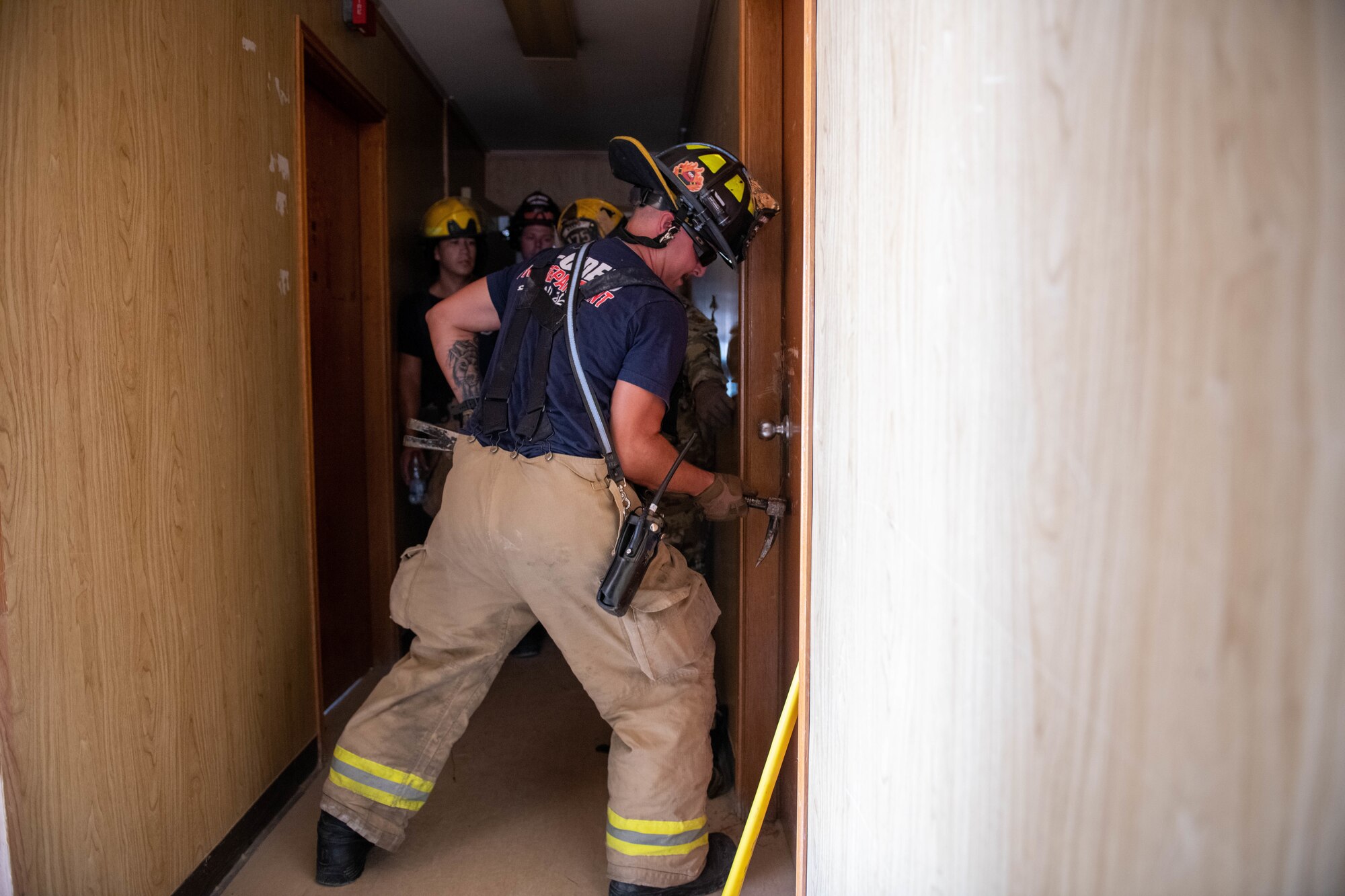 Firefighters with the 379th Expeditionary Civil Engineer Squadron break down a door during a forced entry exercise on Al Udeid Air Base, Qatar, Sept. 7, 2022. Doors in condemned trailers were bolted shut prior to the forced entry exercise. (U.S. Air National Guard photo by Airman 1st Class Constantine Bambakidis)