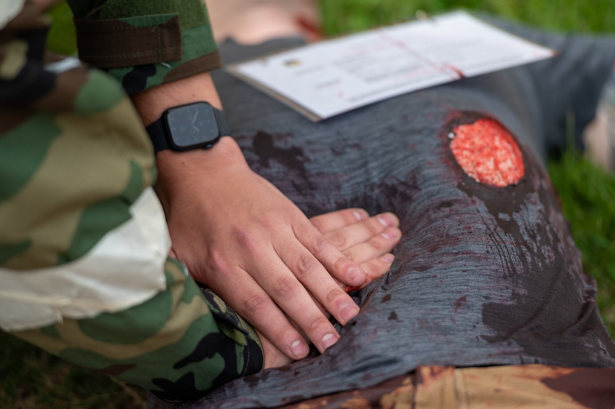 U.S. Air Force Airman Samuel Baldwin, 51st Force Support Squadron shelter management team member, applies pressure using tactical combat casualty care (TCCC) methods to a simulated abdominal wound during a base-wide training event