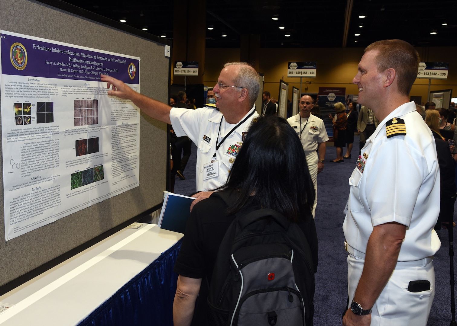 KISSIMMEE, Fla. – (Sept. 13, 2022) – Surgeon General of the Navy, Rear. Adm. Bruce L. Gillingham visits with Naval Medical Research Unit (NAMRU) San Antonio Commanding Officer Capt. Gerald DeLong, of Belvidere, Ill., and Dr. Heuy-Ching Hetty Wang, of San Antonio, director of Combat Casualty Care and Operational Medicine during a poster session held on day two of the 2022 Military Health System Research Symposium (MHSRS) held at the Gaylord Palms Resort and Convention Center. The 2022 MHSRS brings together military, government, academia, and industry experts for four days of critical conversations and intensive idea sharing. Presenters will share their latest research findings and challenges on topics including combat casualty care, military operational medicine, clinical and rehabilitative medicine, medical simulation and information sciences, military infectious diseases, and the radiation health effects. NAMRU San Antonio is one of the leading research and development laboratories for the U.S. Navy under the Department of Defense and is one of eight subordinate research commands in the global network of laboratories operating under the Naval Medical Research Center in Silver Spring, Md.  Its mission is to conduct gap driven combat casualty care, craniofacial, and directed energy research to improve survival, operational readiness, and safety of DOD personnel engaged in routine and expeditionary operations. (U.S. Navy photo by Burrell Parmer, NAMRU San Antonio Public Affairs/Released)