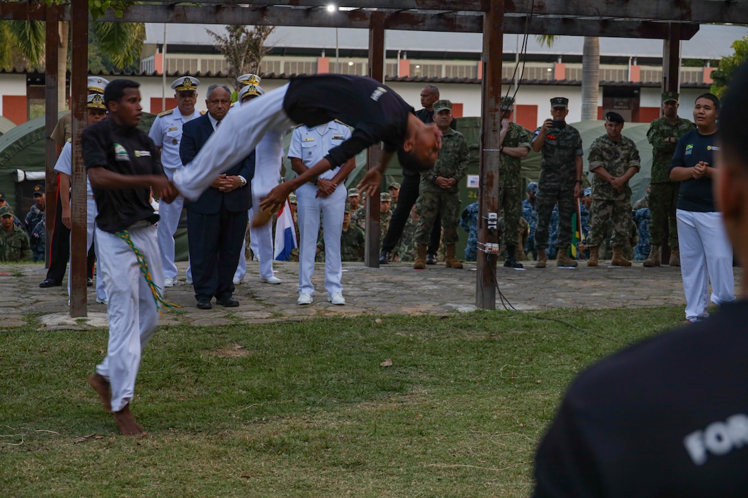 U.S. Secretary of the Navy Carlos Del Toro, and other distinguished guests, watch a Brazilian youth group demonstrate capoeira, a Brazilian martial art form, while visiting multinational service members in Ilha do Governador, Rio de Janeiro during exercise UNITAS LXIII, Sept. 8, 2022. UNITAS is the world’s longest-running annual multinational maritime exercise that focuses on enhancing interoperability among multiple nations and joint forces during littoral and amphibious operations in order to build on existing regional partnerships and create new enduring relationships that promote peace, stability, and prosperity in the U.S. Southern Command’s area of responsibility. (U.S. Marine Corps photo by Lance Cpl. Trystan Taft)