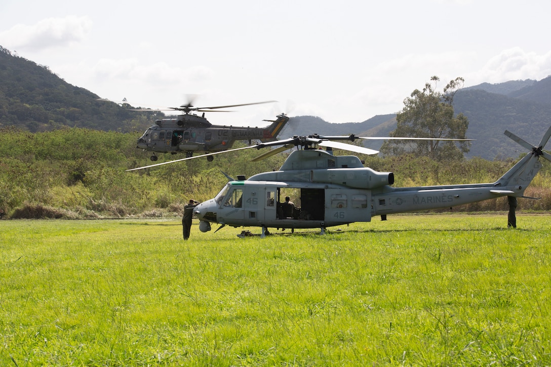 U.S. Marines with Marine Light Attack Helicopter Squadron - 773, 4th Marine Aircraft Wing, Marine Forces Reserve in support of Special Purpose Marine Air-Ground Task Force UNITAS LXIII, observe a Brazilian UH-15 Super Cougar take off from the parachute operations loading zone at Santa Cruz Air Force Base, Rio de Janeiro, during exercise UNITAS LXIII, Sept. 6, 2022. Integrated operations enable interoperability and the sharing of knowledge between partner nation forces in the exercise. UNITAS develops and sustains relationships that improve the capacity of our reemerging and enduring maritime partners to achieve common objectives. Additionally, the military-to-military exchanges foster mutual cooperation and understanding among participating navies and marine corps. (U.S. Marine Corps photo by 1st Lt. Mark L. Andries)