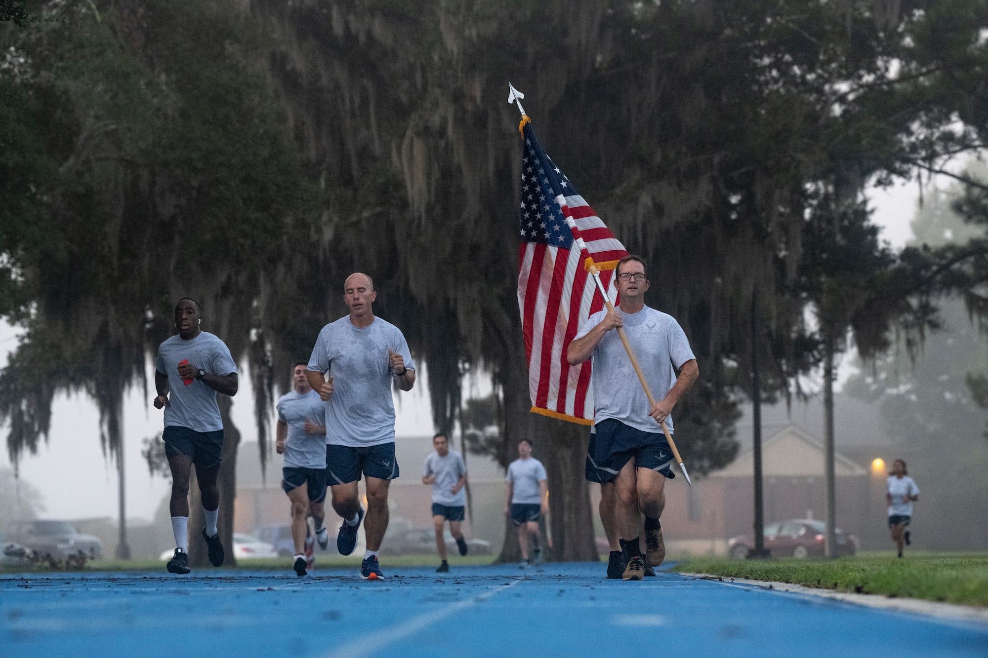 Airmen hold a U.S. flag during a 9/11 remembrance run.