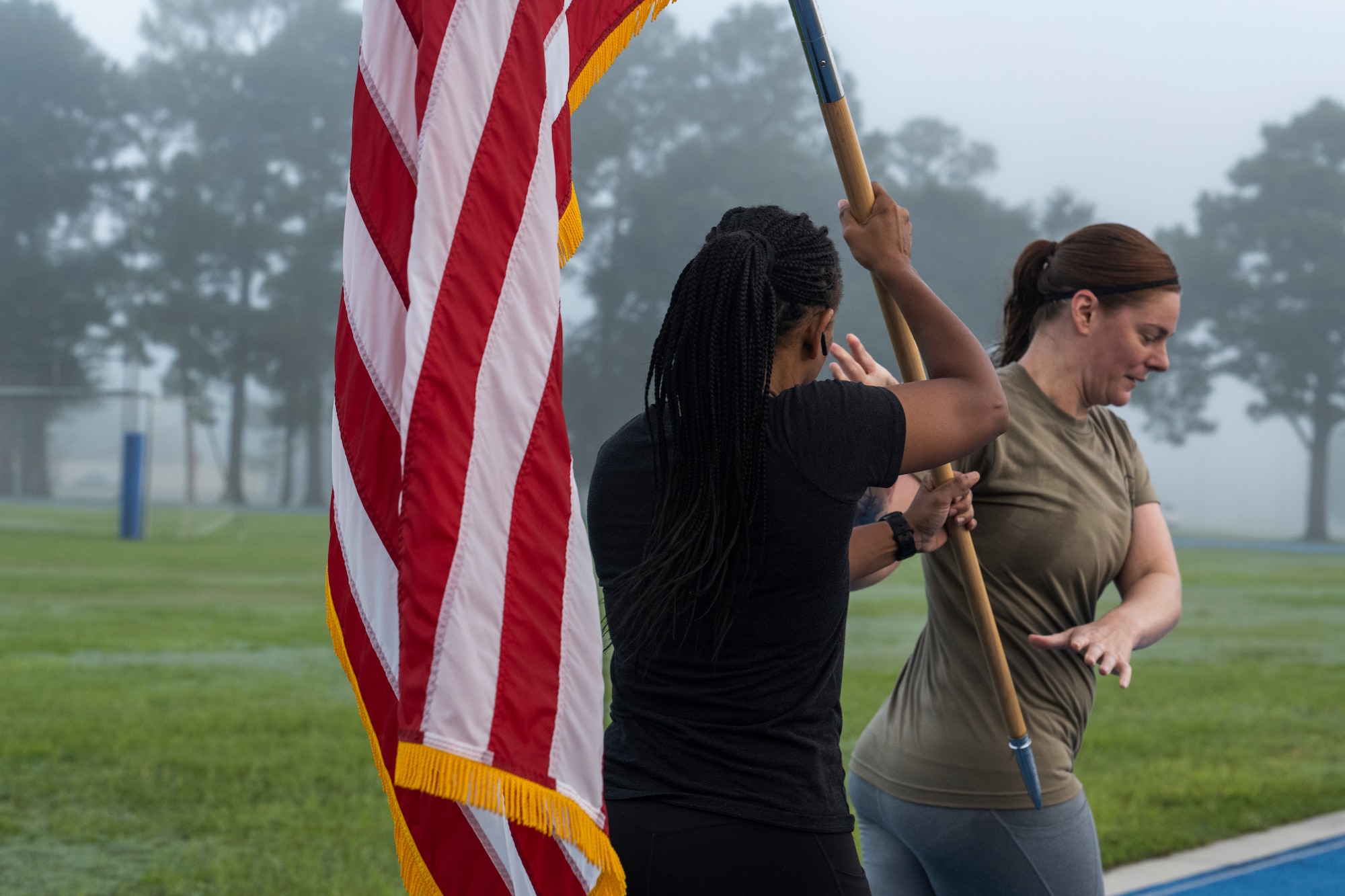Airman passes a U.S. flag to the next runner