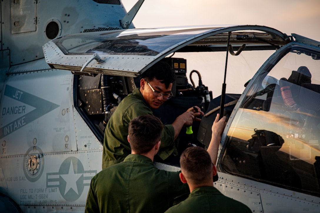 Cpl. Kevin Yoon (top), an avionics technician, with Marine Light Attack Helicopter Squadron - 773, 4th Marine Aircraft Wing, Marine Forces Reserve in support of Special Purpose Marine Air-Ground Task Force UNITAS LXIII, conducts routine maintenance on an AH-1Z Viper at São Pedro da Aldeia, Brazil, during exercise UNITAS LXIII, Sept. 7, 2022. UNITAS is the world's longest-running annual multinational maritime exercise that focuses on enhancing interoperability among multiple nations and joint forces during littoral and amphibious operations in order to build on existing regional partnerships and create new enduring relationships that promote peace, stability, and prosperity in the U.S. Southern Command’s area of responsibility. Yoon is a native of Sacramento, CA. (U.S. Marine Corps photo by 1st Lt. Mark L. Andries)
