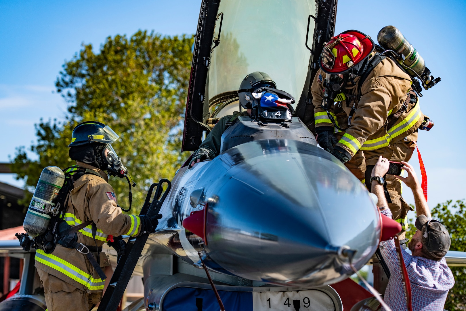 Michael Hillard (left), 902d Civil Engineer Squadron firefighter, and Andrew Sanchez (right), 902d CES lead firefighter, extract a pilot during an emergency response egress exercise for an F-16 Fighting Falcon at Joint Base San Antonio-Lackland Aug. 19, 2022.