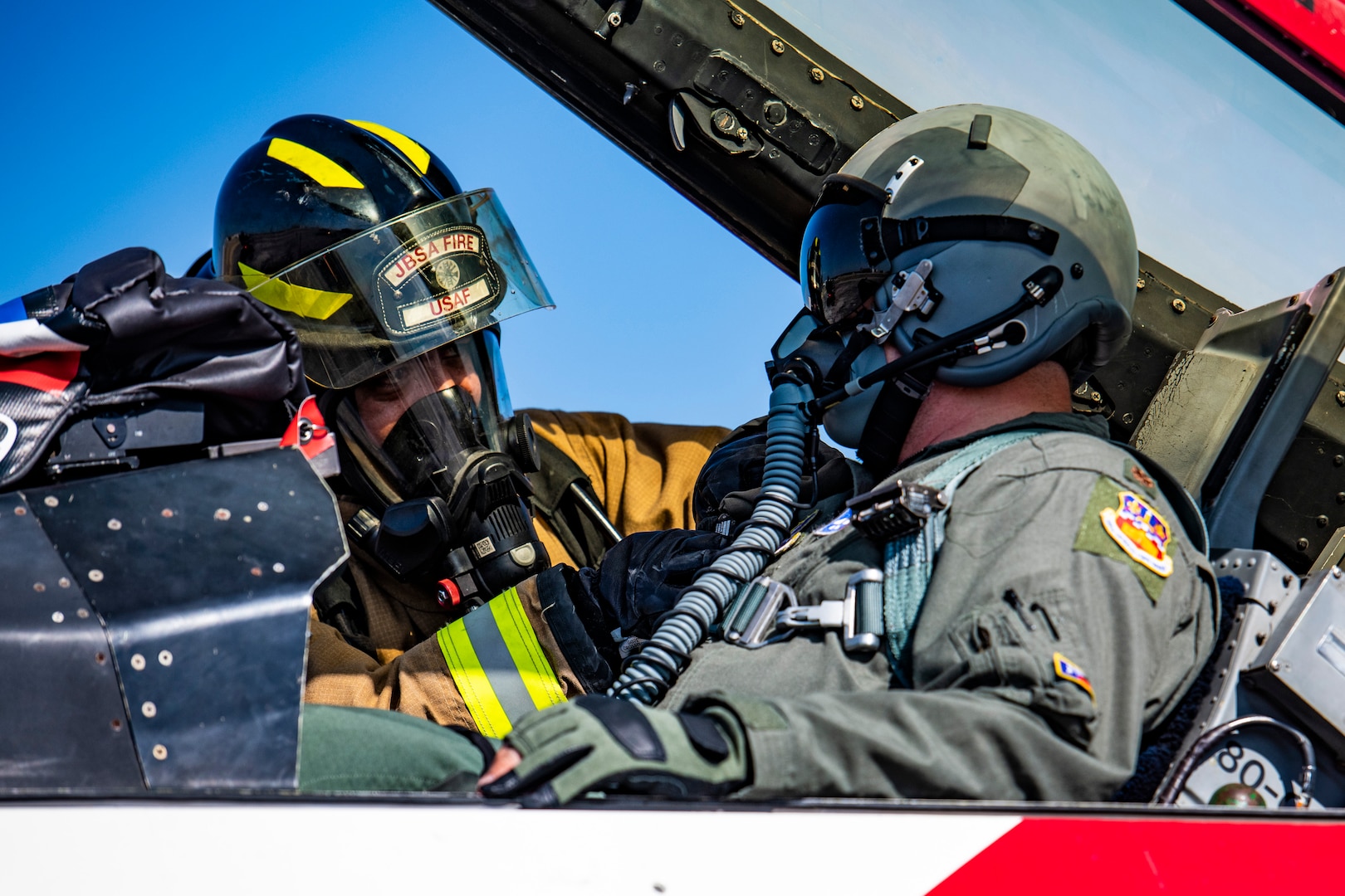 Michael Hillard, 902nd Civil Engineer Squadron firefighter, prepares Maj. Benjamin Wong, 149th Fighter Wing training officer, for extraction during an emergency response egress exercise for an F-16 Fighting Falcon at Joint Base San Antonio-Lackland, Texas, Aug. 19, 2022.