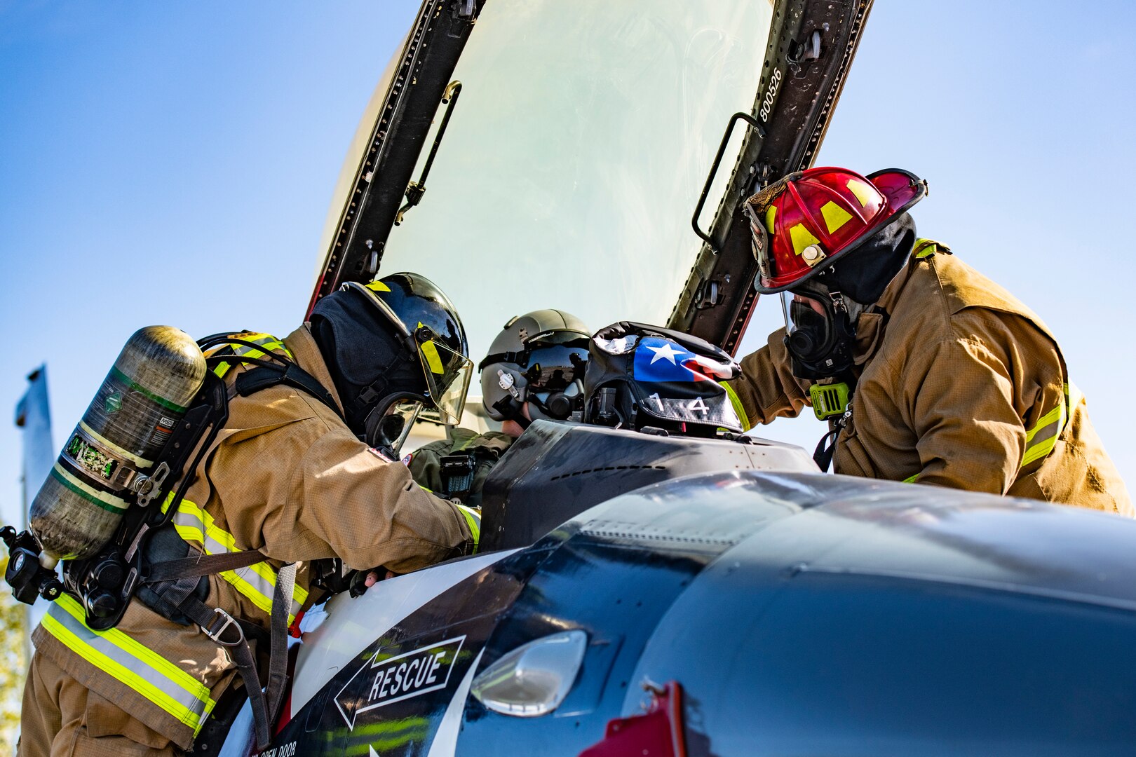 Michael Hillard (left), 902nd Civil Engineer Squadron firefighter, and Andrew Sanchez (right), lead firefighter, extract a pilot during an emergency response egress exercise for an F-16 Fighting Falcon at Joint Base San Antonio-Lackland, Texas, Aug. 19, 2022.