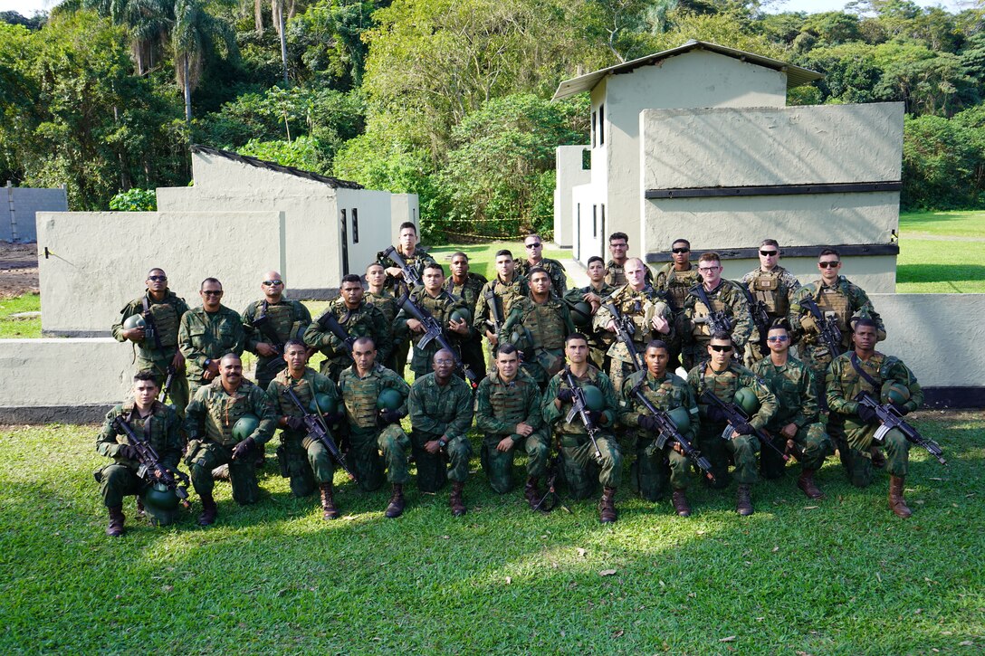 Brazilian Marines alongside United States Marines from Lima Company, 3rd Battalion, 25th Marine Regiment, 4th Marine Division, Marine Forces Reserve in support of Special Purpose Marine Air-Ground Task Force UNITAS LXIII, pose for a group photo following Military Operations in Urban Terrain (MOUT) training at Ilha do Governador, Rio de Janeiro, Sept. 7, 2022.  UNITAS, which is Latin for ‘unity,’ trains forces from across the globe in South America to conduct joint maritime operations through the execution of anti-surface, anti-submarine, anti-air, amphibious, urban warfare, and electronic warfare operations that enhance warfighting proficiency and increase interoperability among participating navy and marine forces. (U.S. Marine Corps photo by Maj. Jeremy Wheeler)