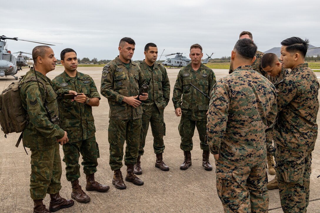 U.S. Marines with 4th Air Naval Gunfire Liaison Company, Force Headquarters Group, Marine Forces Reserve, in support of Special Purpose Marine Air-Ground Task Force UNITAS LXIII, talk through communications operations with Brazilian Marines in São Pedro da Aldeia, Brazil, during exercise UNITAS LXIII, Sept. 4, 2022. U.S. Marines and Brazilian Marines used this time to convey communication procedures and safety actions before flights began. UNITAS is the world's longest-running annual multinational maritime exercise that brings together forces from 19 countries to include Brazil, Cameroon, Chile, Colombia, Dominican Republic, Ecuador, France, Guyana, Jamaica, Mexico, Namibia, Panama, Paraguay, Peru, South Korea, Spain, United Kingdom, Uruguay, and the United States. The exercise focuses on enhancing interoperability among multiple nations and joint forces during littoral and amphibious operations in order to build on existing regional partnerships and create new enduring relationships that promote peace, stability and prosperity in the U.S. Southern Command’s area of responsibility. (U.S. Marine Corps photo by Cpl. Jonathan L. Gonzalez)