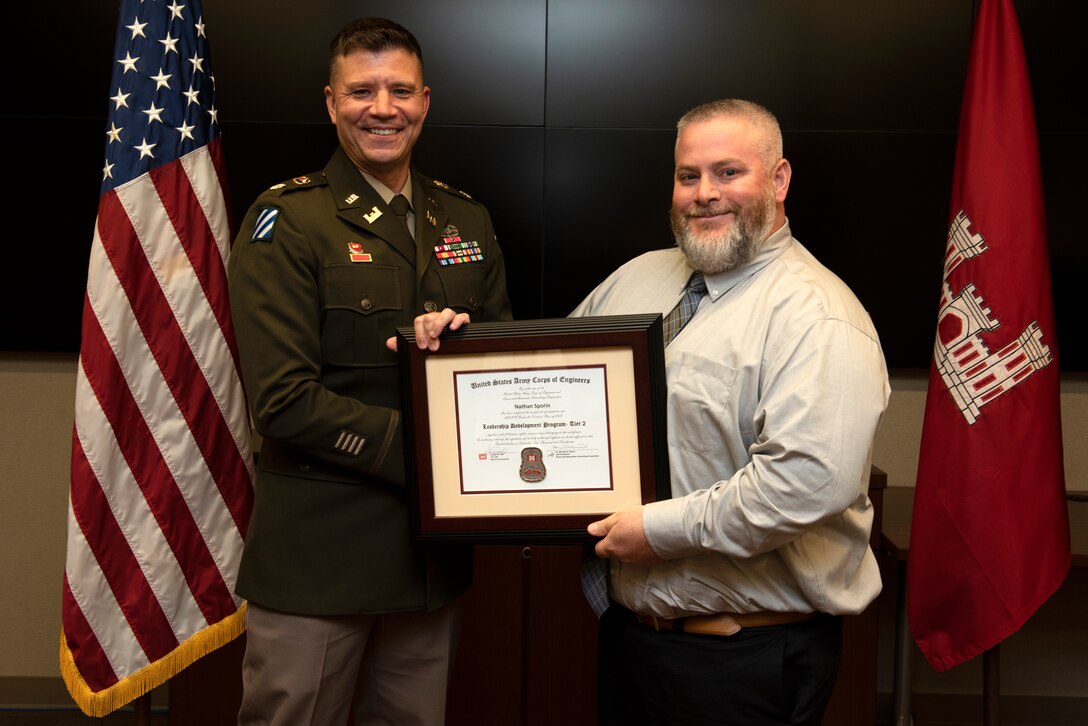 Nathan Sporin, U.S. Army Corps of Engineers Nashville District, receives a certificate of completion for the 2022 Leadership Development Program Level II Course from Lt. Col. Joseph Sahl, Nashville District commander, and Michael Evans, course instructor, during a graduation ceremony Sept. 14, 2022, at the district headquarters in Nashville, Tennessee. (USACE Photo by Lee Roberts)