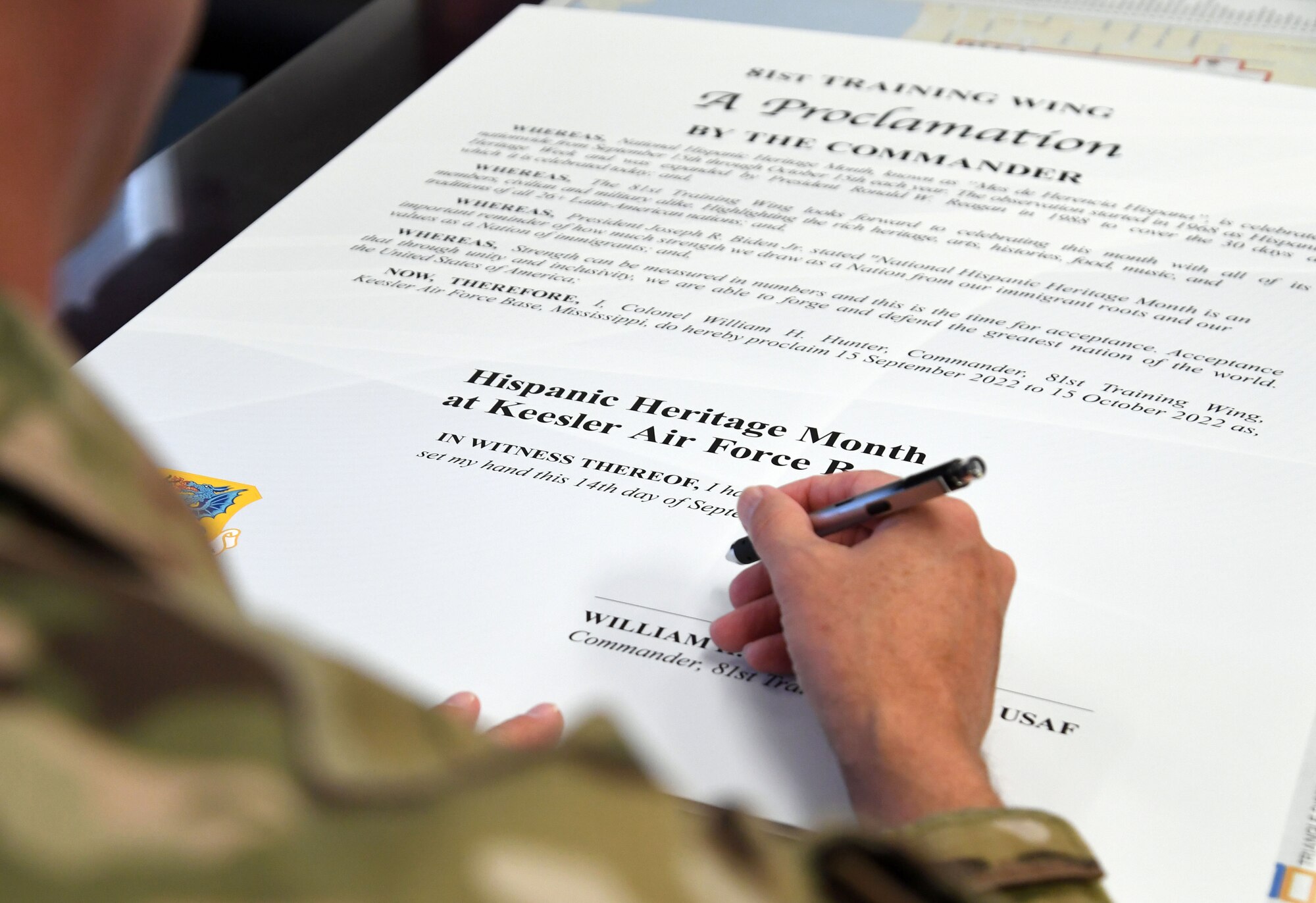 U.S. Air Force Col. William Hunter, 81st Training Wing commander, signs the Hispanic Heritage Month proclamation inside the 81st TRW headquarters building at Keesler Air Force Base, Mississippi, Sept. 14, 2022. Hispanic Heritage Month is celebrated September 15 through October 15. (U.S. Air Force photo by Kemberly Groue)