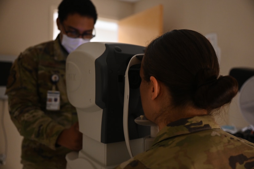 Airman examining a patient's eyes.