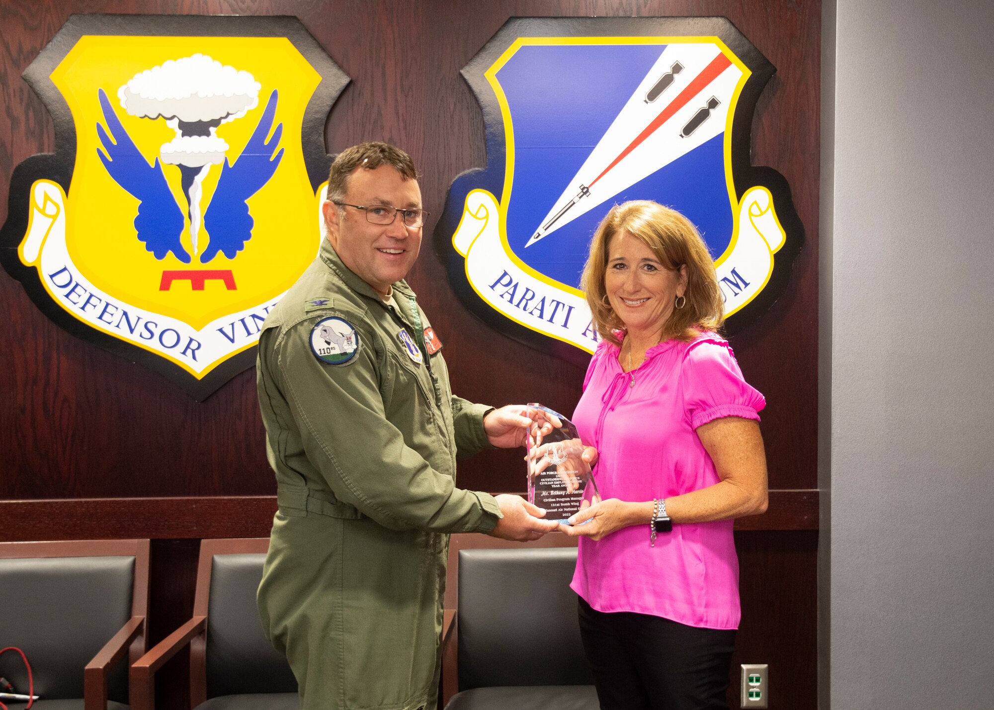 131st Bomb Wing vice commander Col. Jared Kennish presents the Air Force Association's Outstanding Air Force Civilian Employee of the Year Award to Bethany Harris, the wing's director of psychological health, during a commander's call at Whiteman Air Force Base, Mo., Aug. 6, 2022. (U.S. Air National Guard photo by Staff Sgt. Josh Colligan)