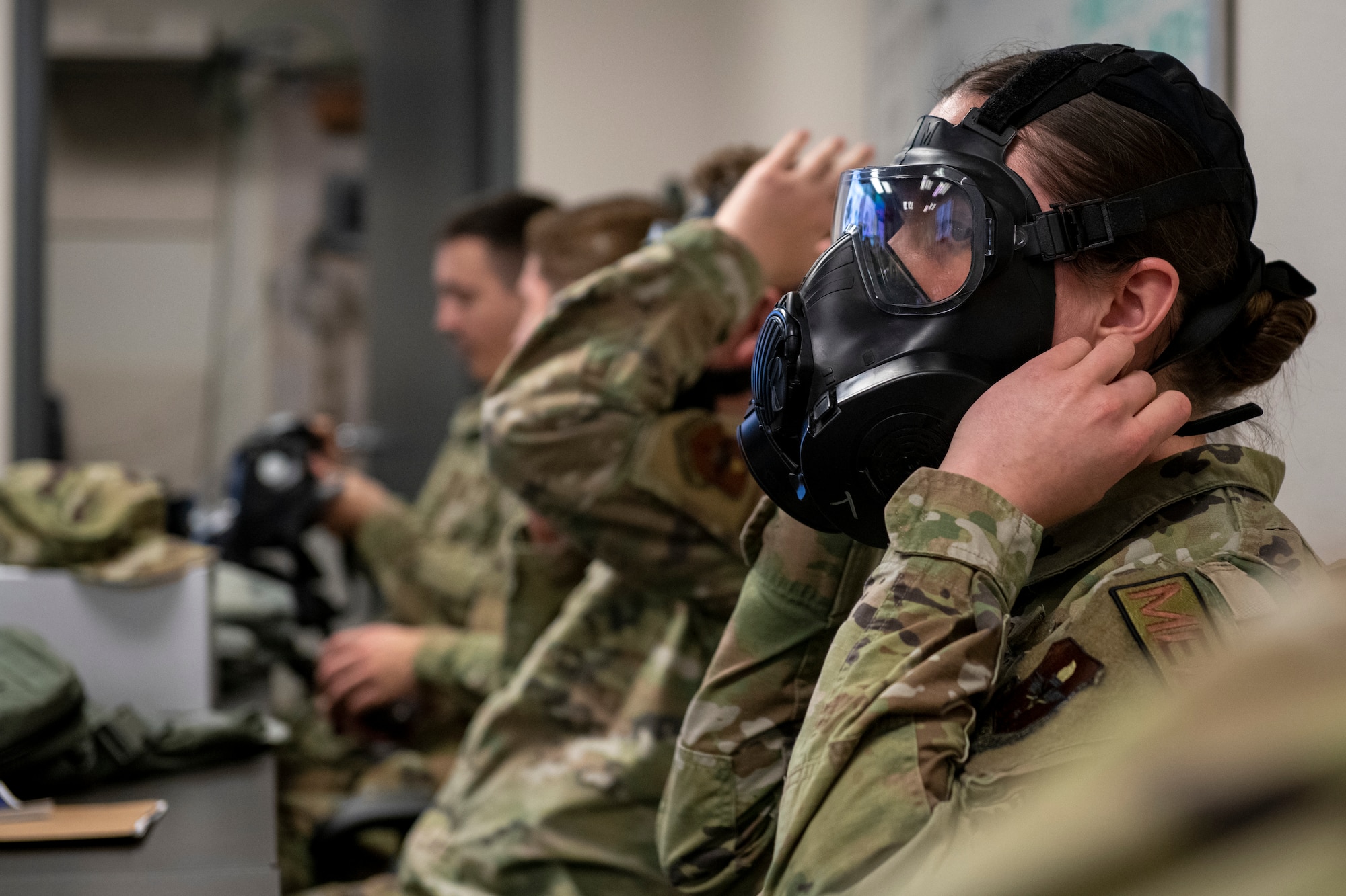 A U.S. Air Force Airman assigned to the 56th Fighter Wing dons an M50 gas mask while participating in a chemical, biological, radiological, nuclear, and high-yield explosives course, during Exercise Crown Talon, May 4, 2022, at Luke Air Force Base, Arizona.