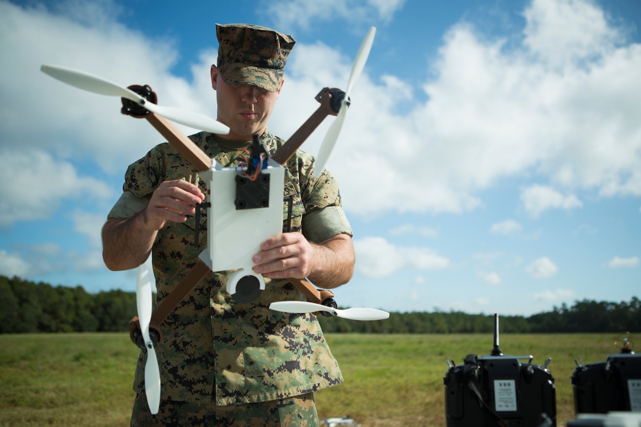 A Marine holds a small aircraft.