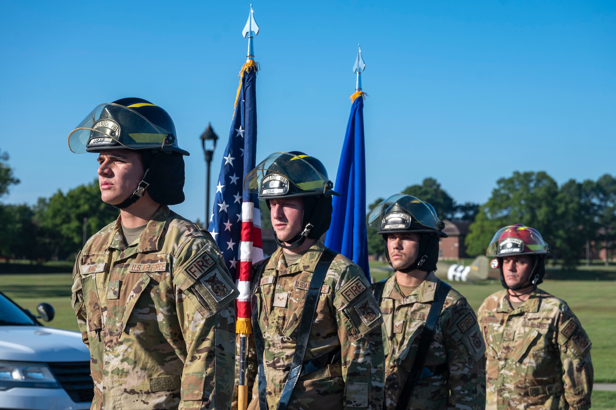 Men in uniform stand with flags