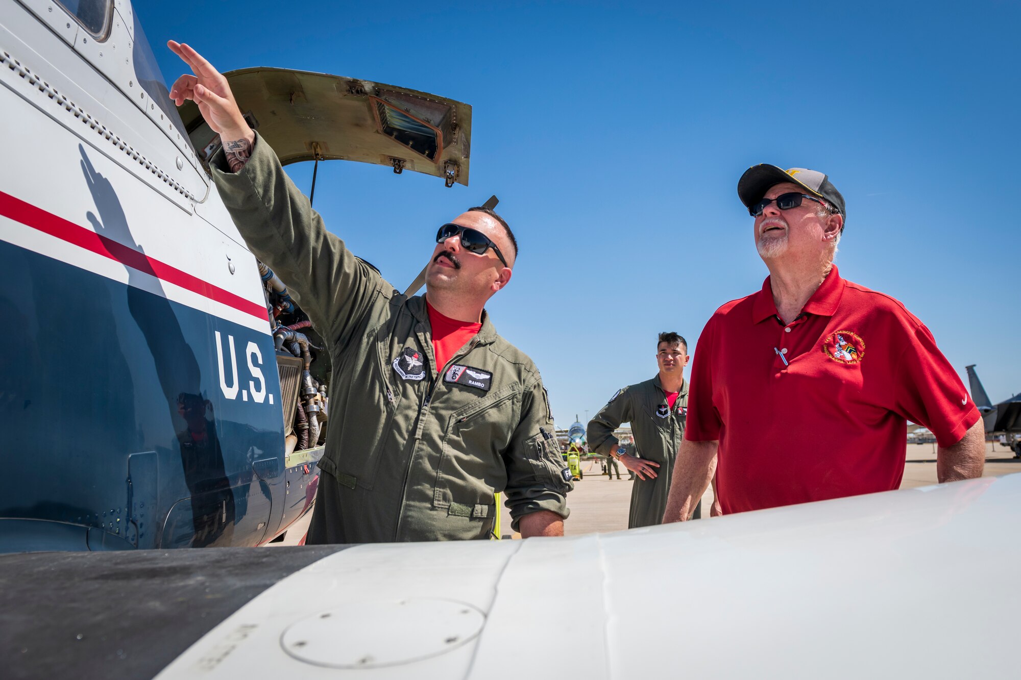U.S. Air Force Capt. Jason Mavrogeorge, 8th Flying Training Squadron instructor pilot, Vance Air Force Base, Oklahoma, explains the features of a T-6A Texan II aircraft to an attendee during Luke AFB’s Supporter Appreciation Day event, May 13, 2022, at Luke AFB, Arizona.