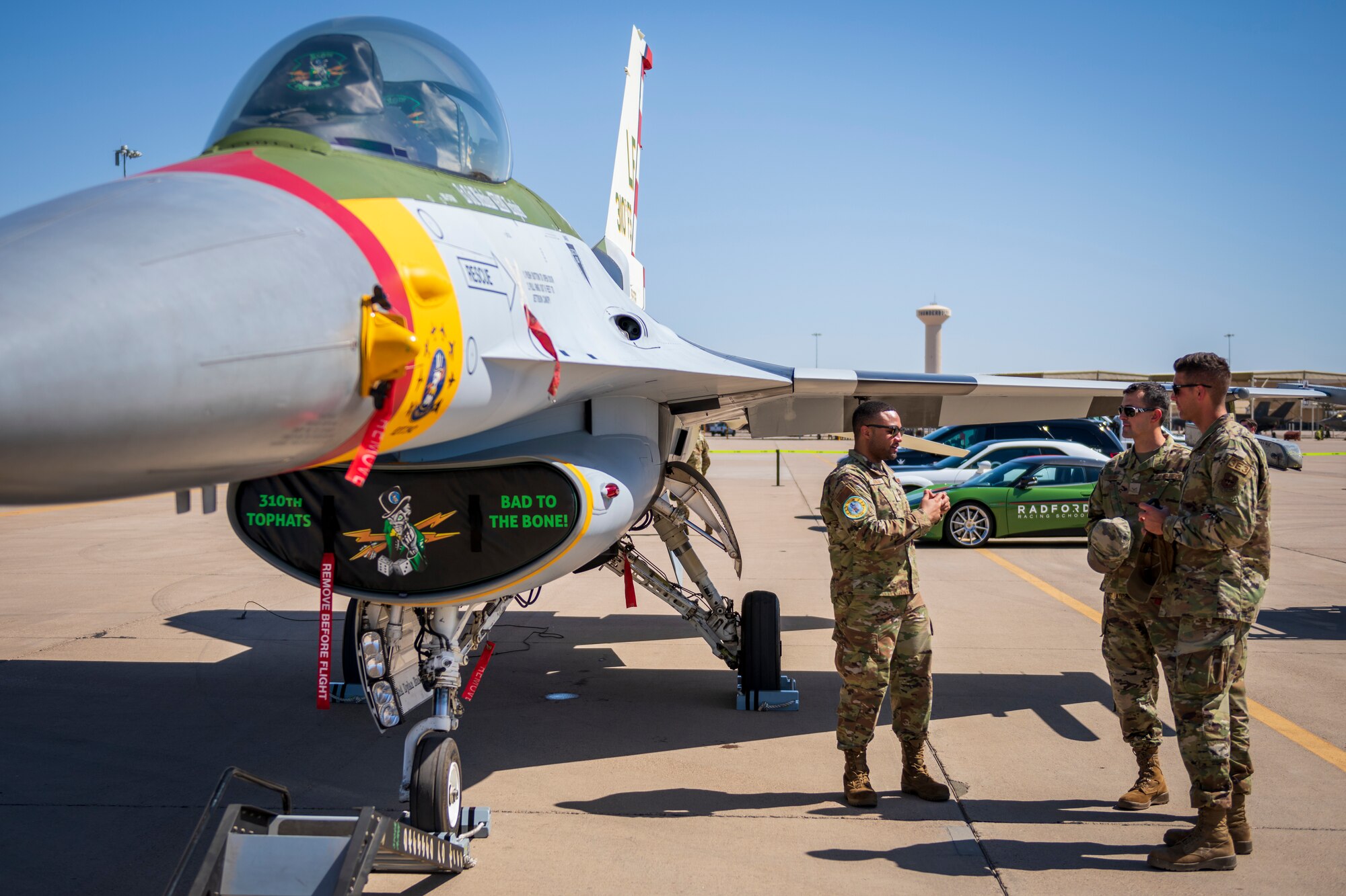 U.S. Air Force Airmen talk near an F-16 Fighting Falcon assigned to the 310th Fighter Squadron, during Luke Air Force Base’s Supporter Appreciation Day event, May 13, 2022, at Luke AFB, Arizona.