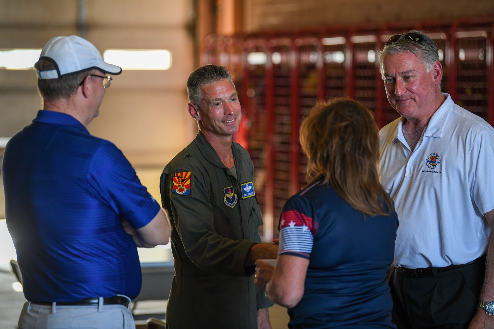 U.S. Air Force Brig. Gen. Gregory Kreuder (center), 56th Fighter Wing commander, shakes hands with a civic leader during Luke Air Force Base’s Supporter Appreciation Day event, May 13, 2022, at Luke AFB, Arizona.