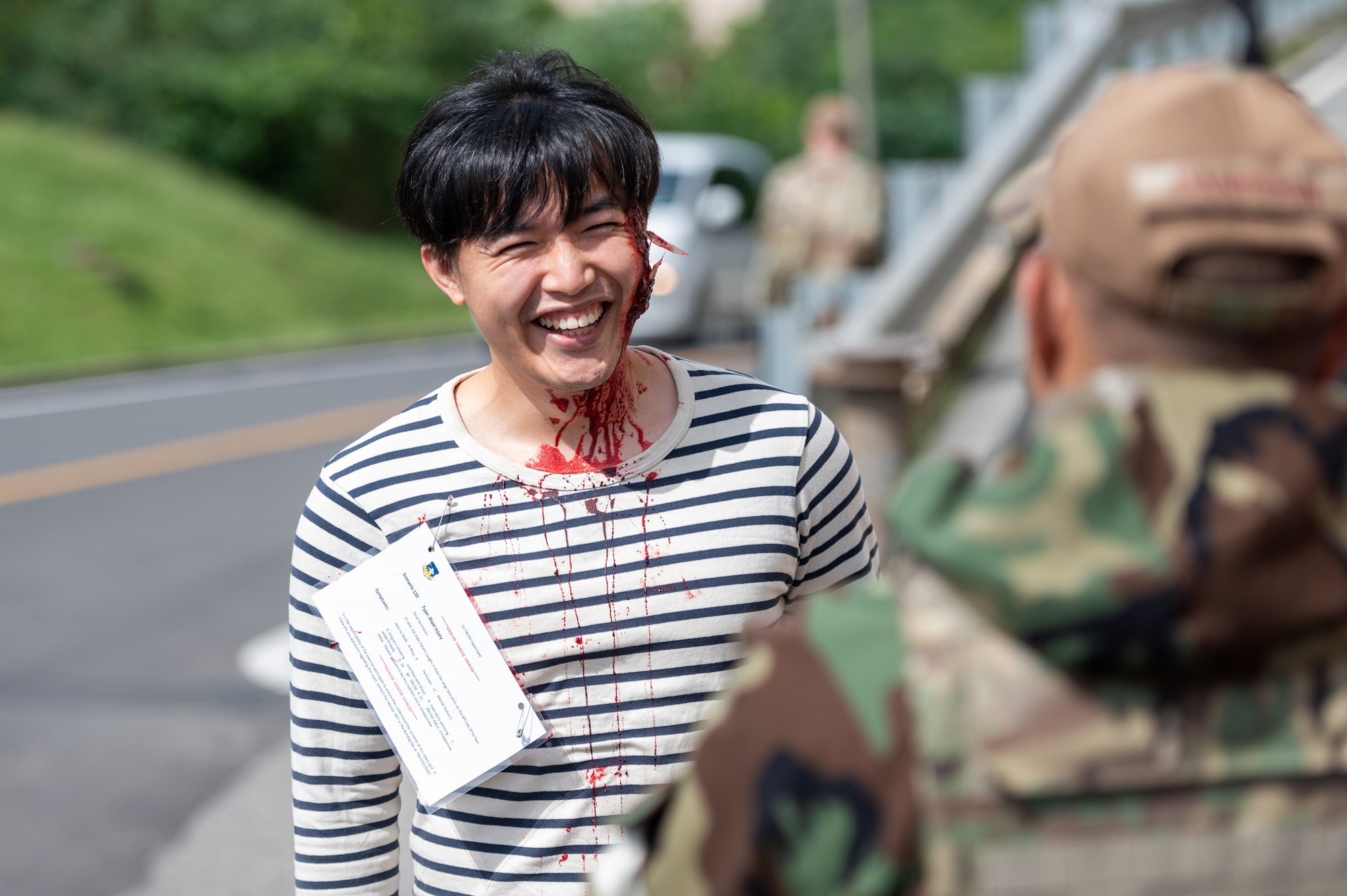 Kwangpil Pak, 51st Medical Group simulated trauma victim, receives instructions from U.S. Air Force Lt. Col. David Panboon, 51st Medical Group wing inspection team leader, before a mass casualty response training