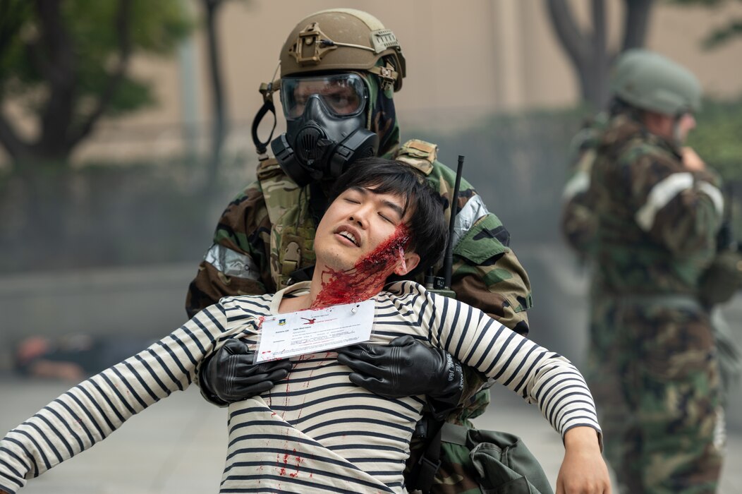 A first responder assigned to the 51st Security Forces Squadron, relocates Kwangpil Pak, 51st Medical Group simulated trauma victim, to a safe extraction point during a mass casualty response training