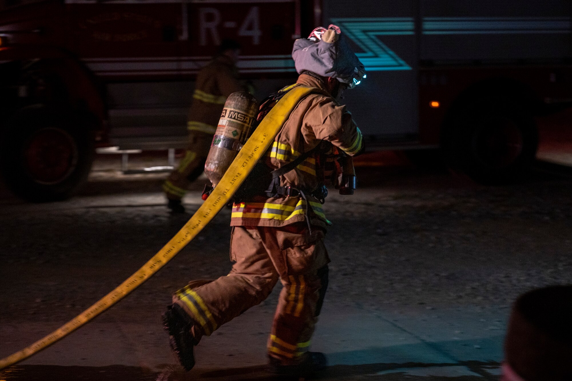 U.S. Air Force Staff Sgt. Larry McIver, 51st Civil Engineer Squadron (CES) lead firefighter, drags a hose after a fire response training scenario at Osan Air Base, Republic of Korea, Sept. 14, 2022.