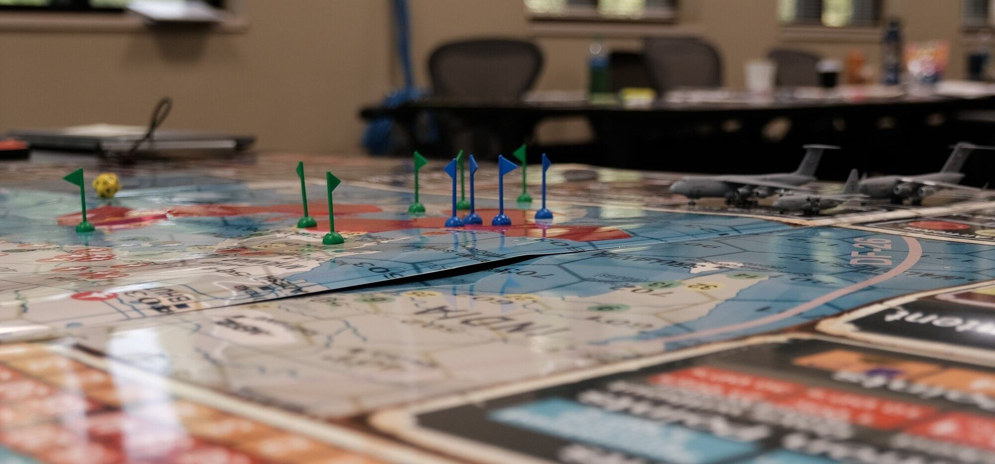 photo of a group of US military standing and sitting around a table looking at map