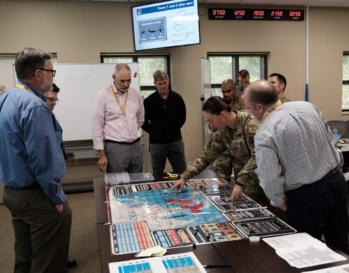 photo of a group of US military standing around a table looking at map