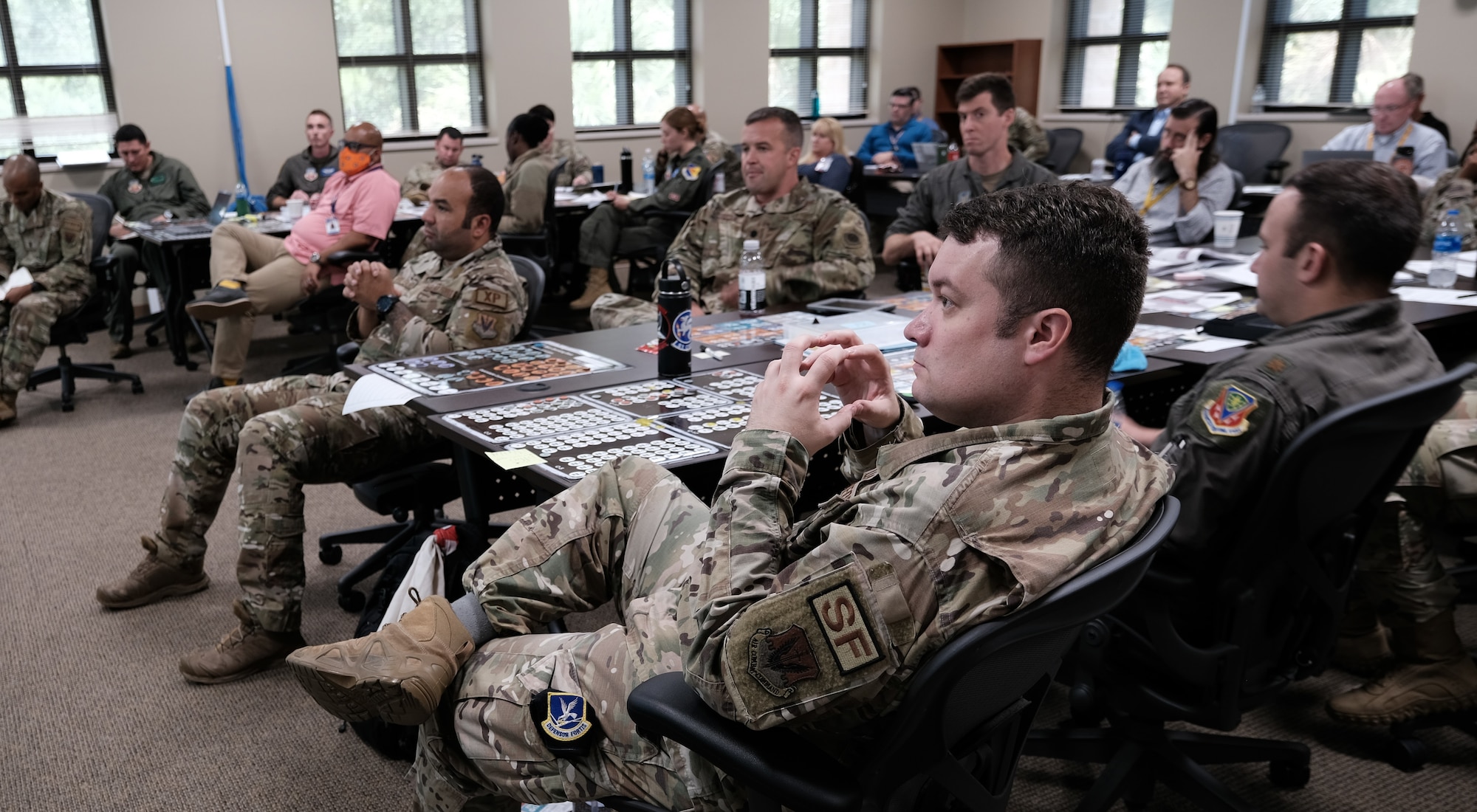photo of a group of US Military sitting in a room at tables