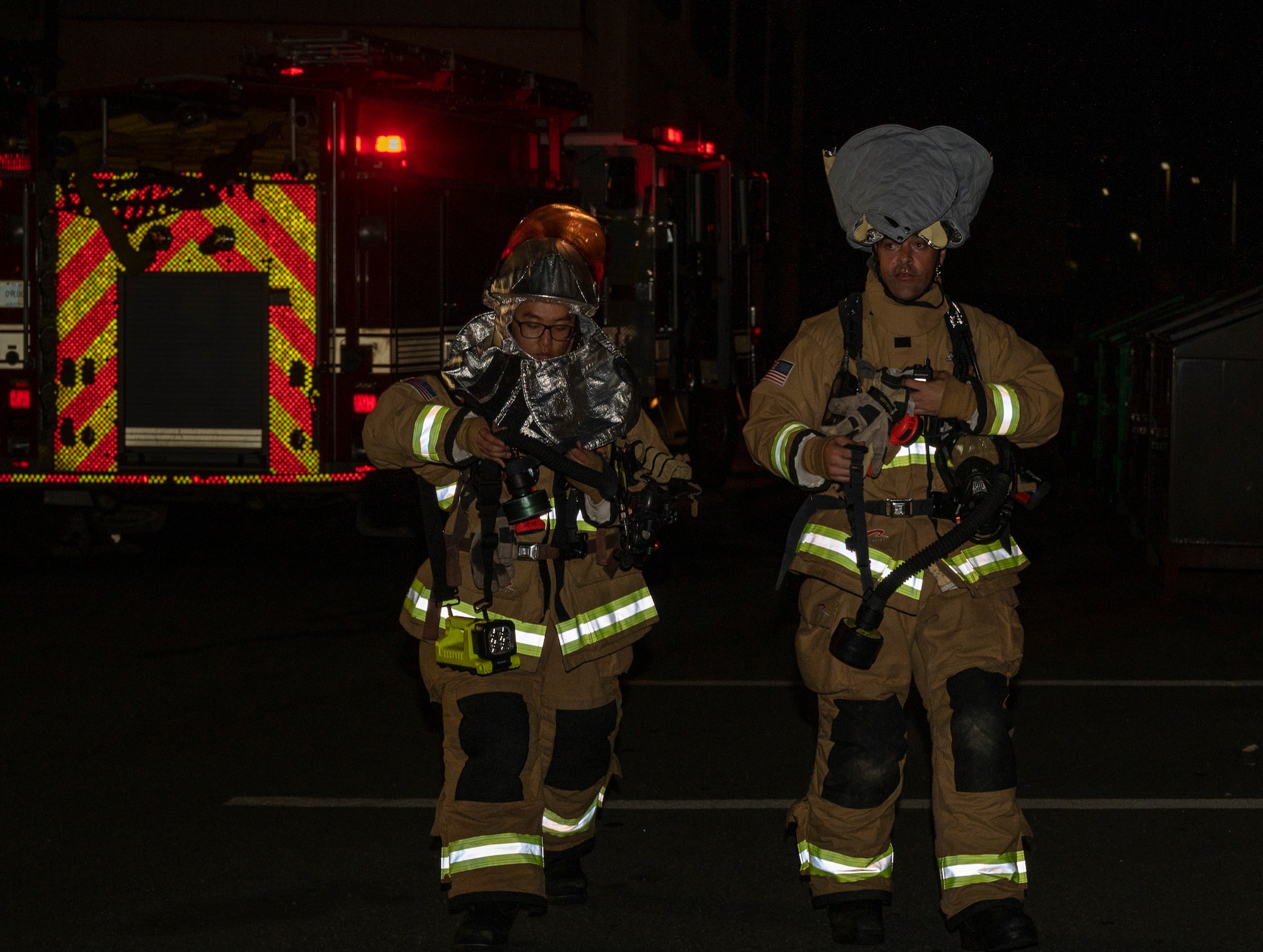 U.S. Air Force Airman 1st Class Joey Vue and U.S. Air Force Staff Sgt. Larry McIver, 51st Civil Engineer Squadron firefighters, don their fire gear during a fire response training scenario at Osan Air Base, Republic of Korea, Sept. 14, 2022.
