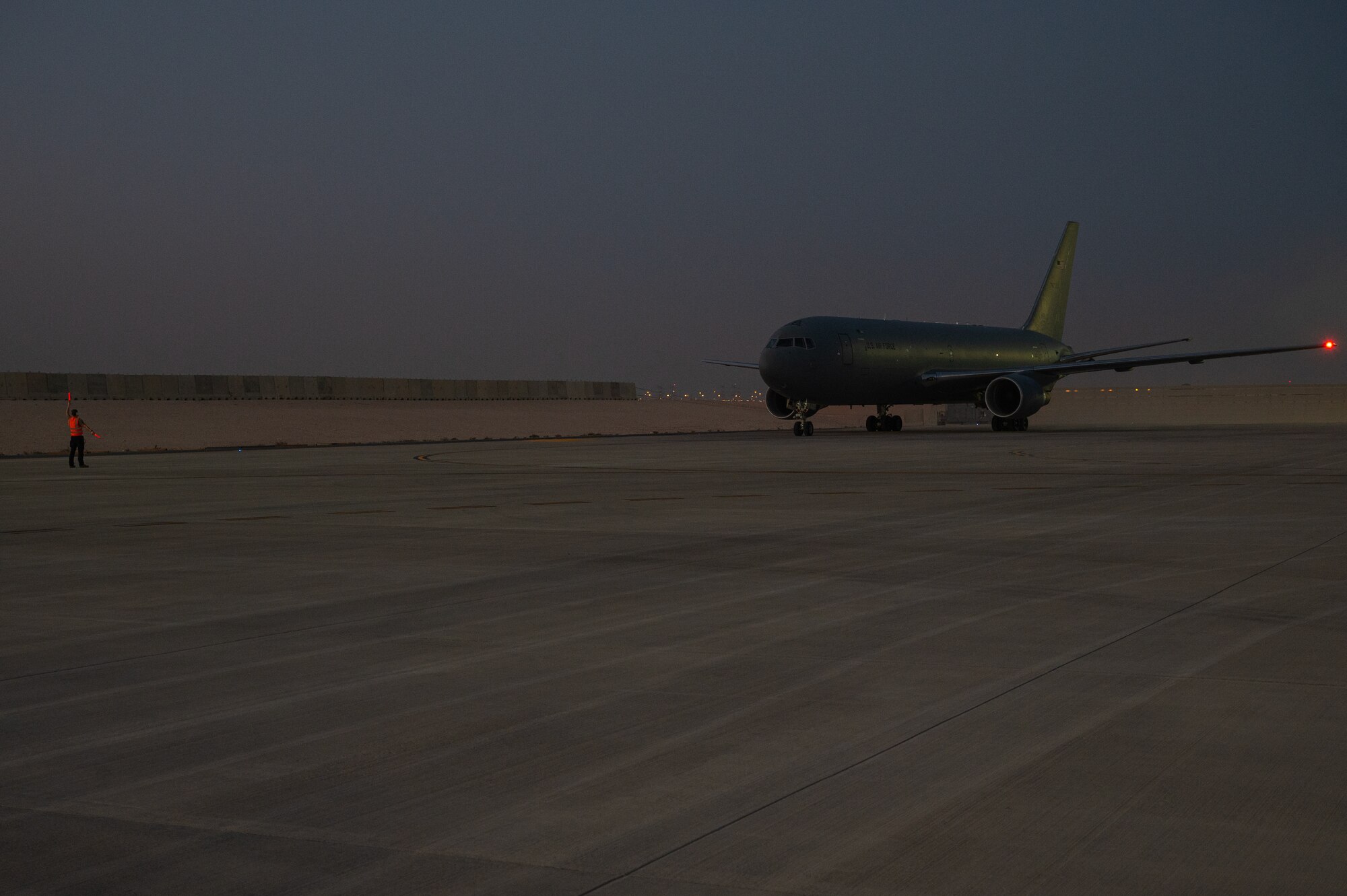 A U.S. Air Force Airman with the 379th Air Expeditionary Aircraft Maintenance Squadron marshals a KC-46A Pegasus based out of McConnell Air Force Base, Kansas, Aug. 26, 2022, at Al Udeid Air Base, Qatar.