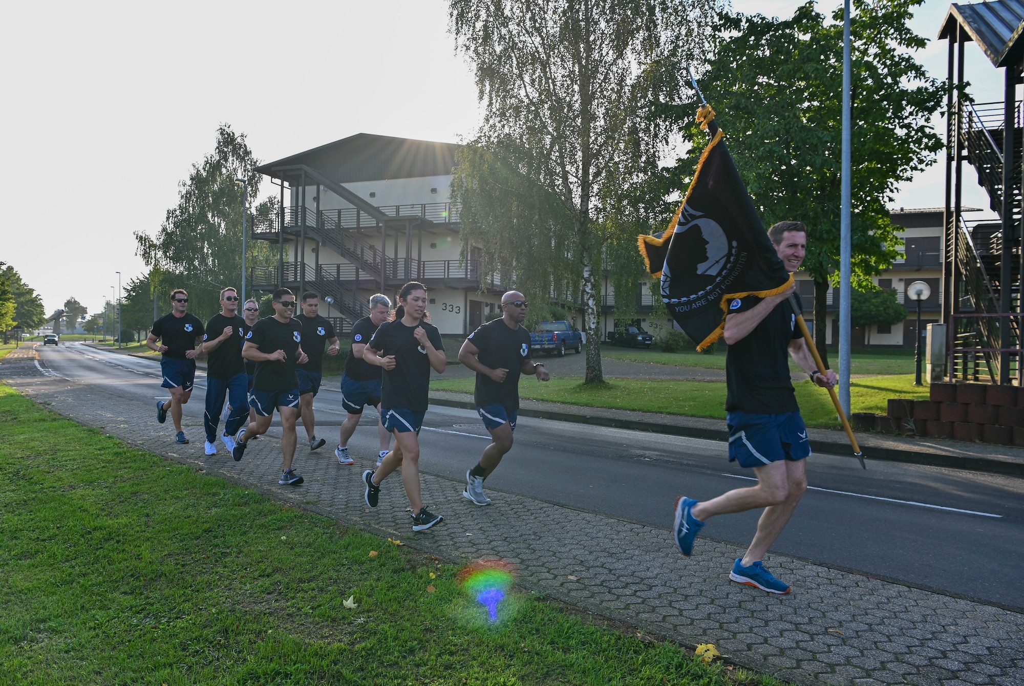 Unit commanders run with POW/MIA flag.