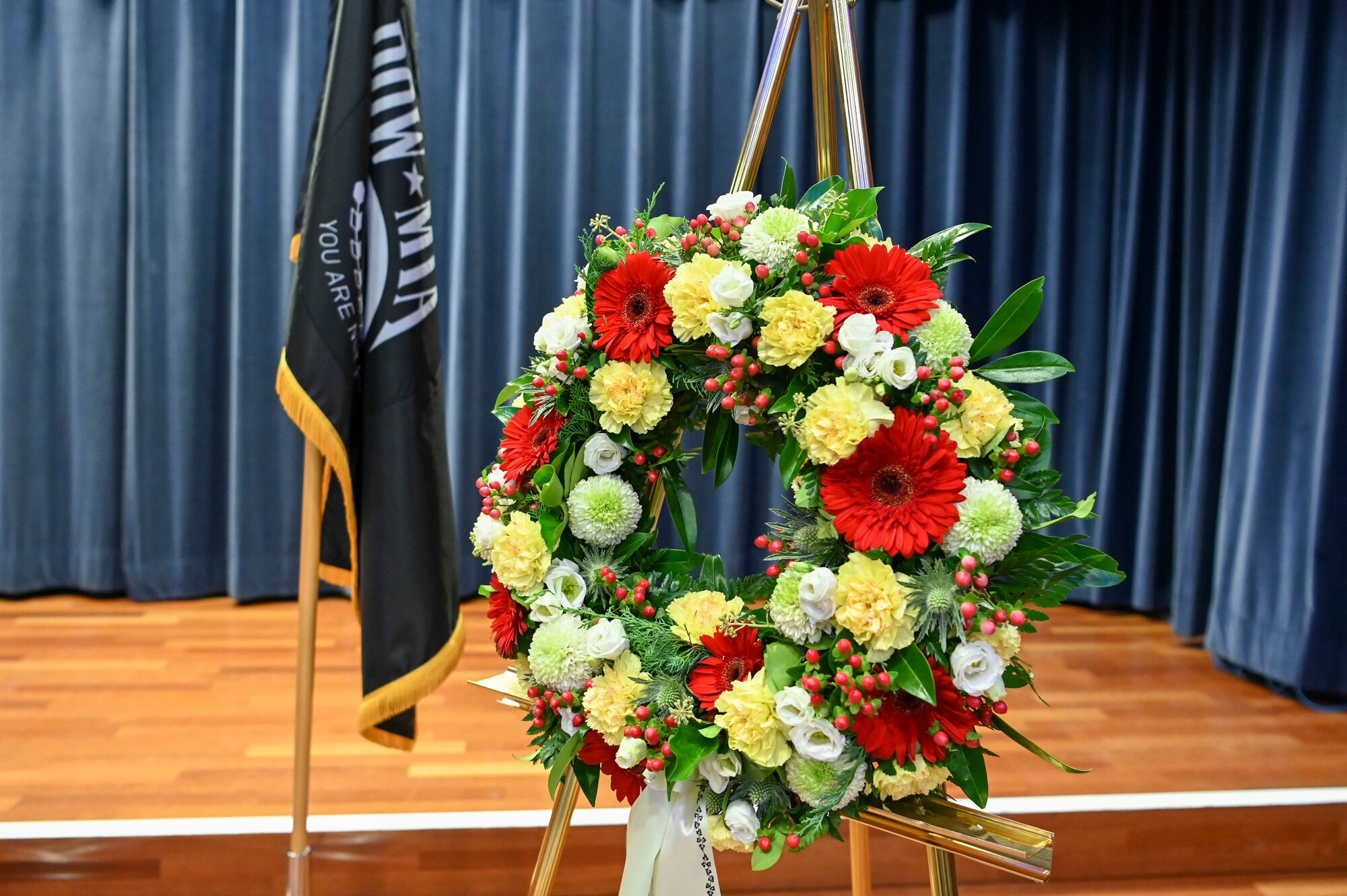 A wreath on display with a POW/MIA flag