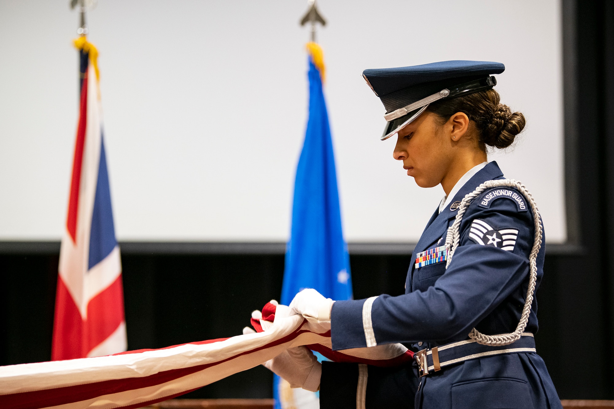 An Airman from the 422d Air Base Group honor guard, folds a flag during a 9/11 retreat ceremony at RAF Croughton, England, Sep. 9, 2022. Airmen and guests participated in the ceremony to honor those who lost their lives during the September 11th terrorist attacks. (U.S. Air Force photo by Staff Sgt. Eugene Oliver)