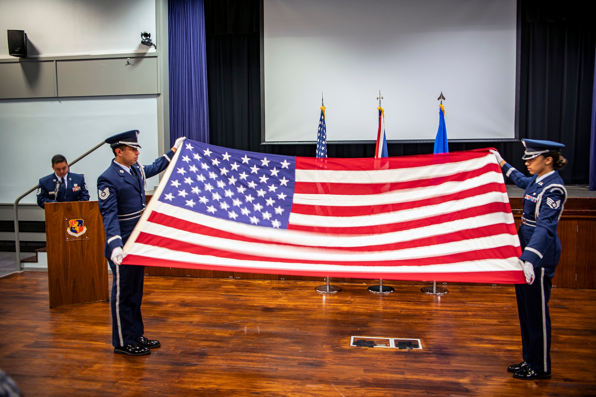 Airmen from the 422d Air Base Group honor guard, hold a flag at the table top position during a 9/11 retreat ceremony at RAF Croughton, England, Sep. 9, 2022. Airmen and guests participated in the ceremony to honor those who lost their lives during the September 11th terrorist attacks. (U.S. Air Force photo by Staff Sgt. Eugene Oliver)