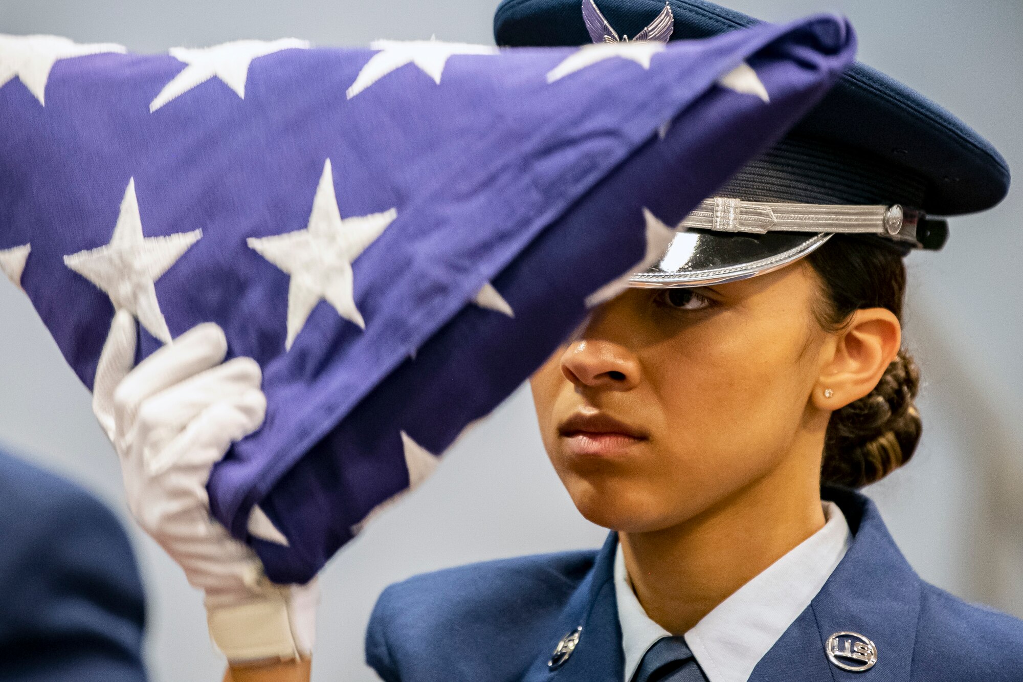 An Airman from the 422d Air Base Group honor guard, holds a folded flag during a 9/11 retreat ceremony at RAF Croughton, England, Sep. 9, 2022. Airmen and guests participated in the ceremony to honor those who lost their lives during the September 11th terrorist attacks. (U.S. Air Force photo by Staff Sgt. Eugene Oliver)