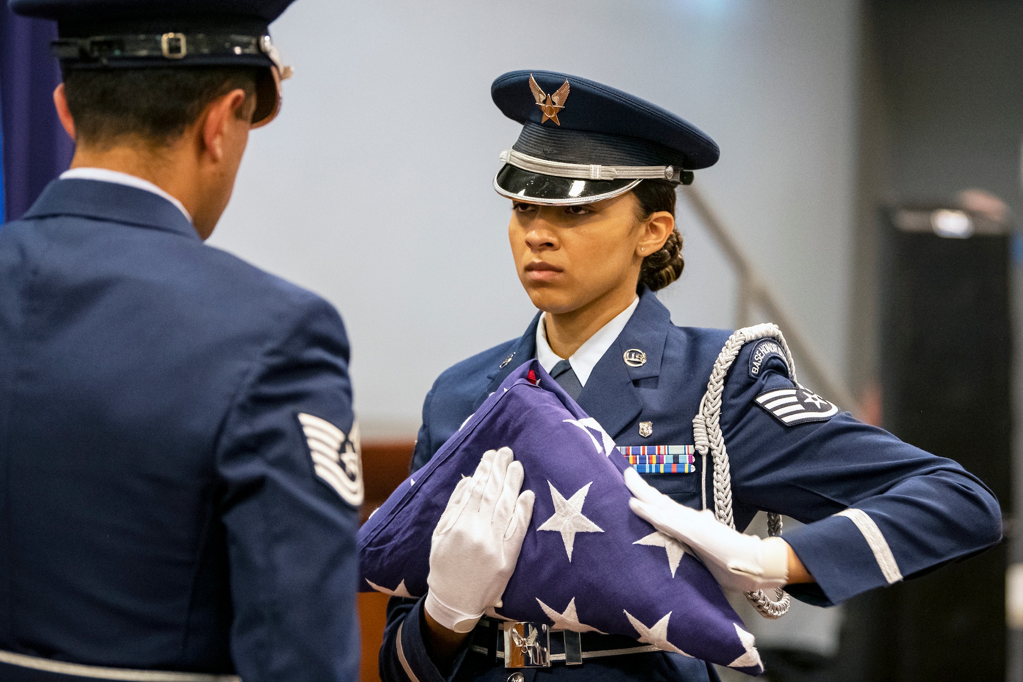 An Airman from the 422d Air Base Group honor guard, dresses a flag during a 9/11 retreat ceremony at RAF Croughton, England, Sep. 9, 2022. Airmen and guests participated in the ceremony to honor those who lost their lives during the September 11th terrorist attacks. (U.S. Air Force photo by Staff Sgt. Eugene Oliver)