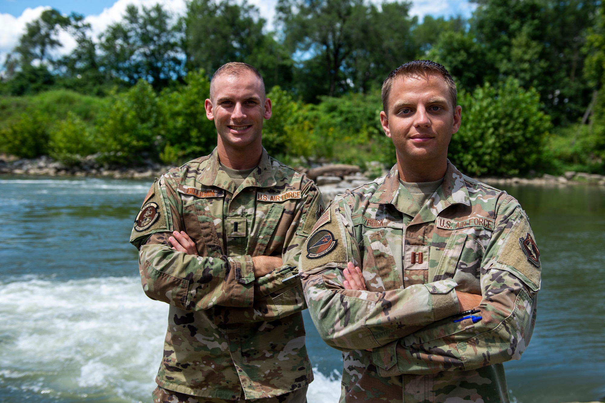 Capt. Dillion Buck and First Lt. Martin Gilligan, both members of the Aircraft Analysis Squadron, pose at the spot where they saved a child from drowning, East MetroPark July 29, 2022. Buck and Gilligan were at the park celebrating the promotion of another member from the squadron before they saved the life of a drowning boy. (U.S. Air Force photo by Staff Sgt. Samuel Earick)