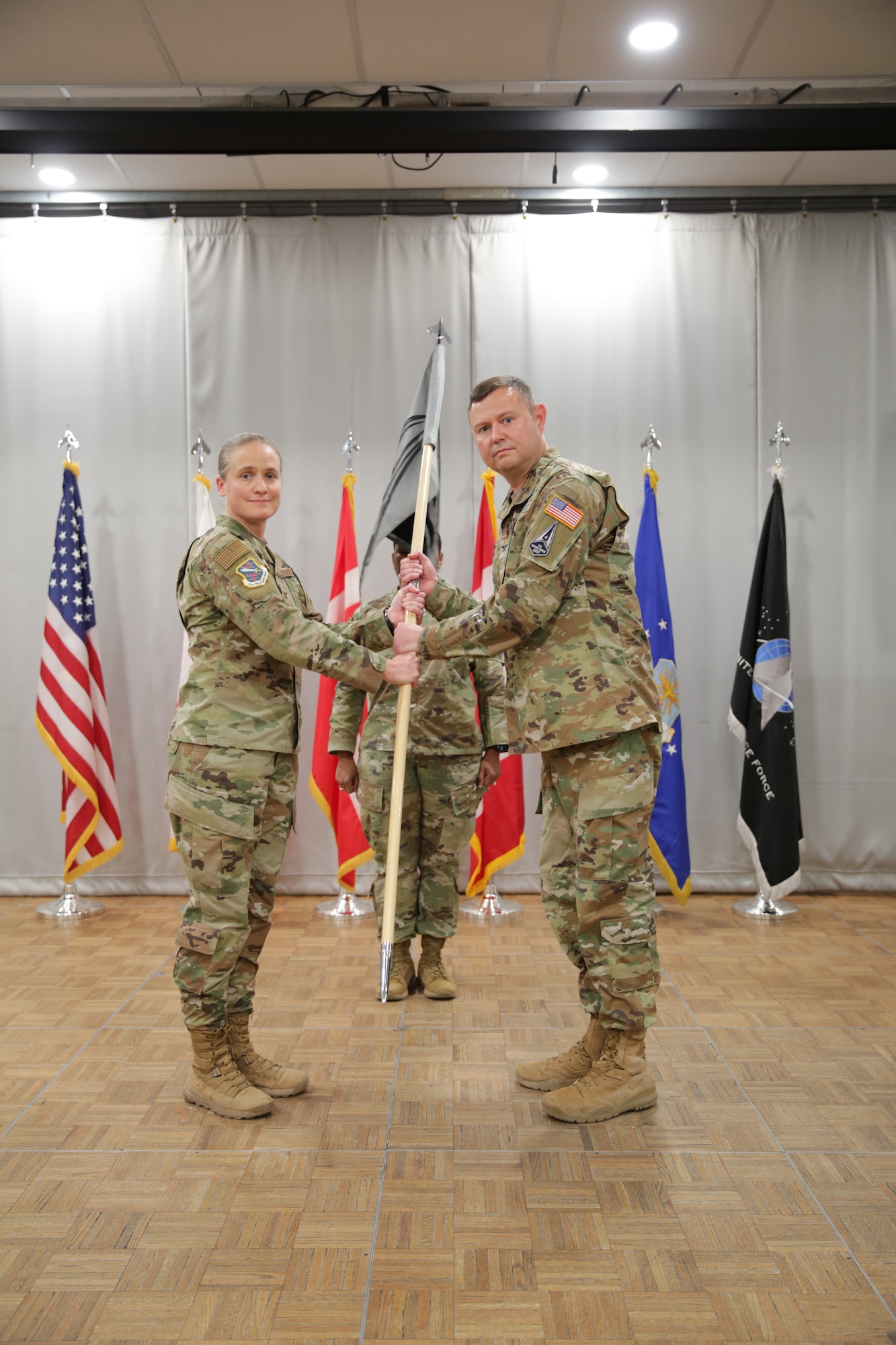 U.S. Air Force Col. Sarah Babbitt, outgoing 821st Space Base Group commander, passes the guidon to the incoming commander, U.S. Space Force Col. Brian Capps, during a change of command ceremony at Thule Air Base, Greenland, Sept. 15, 2022. As the installation commander, Capps is responsible for the administration and security of the Air Force’s largest overseas and the United States’ northernmost military installation comprised in the Thule Defense Area. (U.S. Space Force photo by Master Sgt. Joshua Robley)