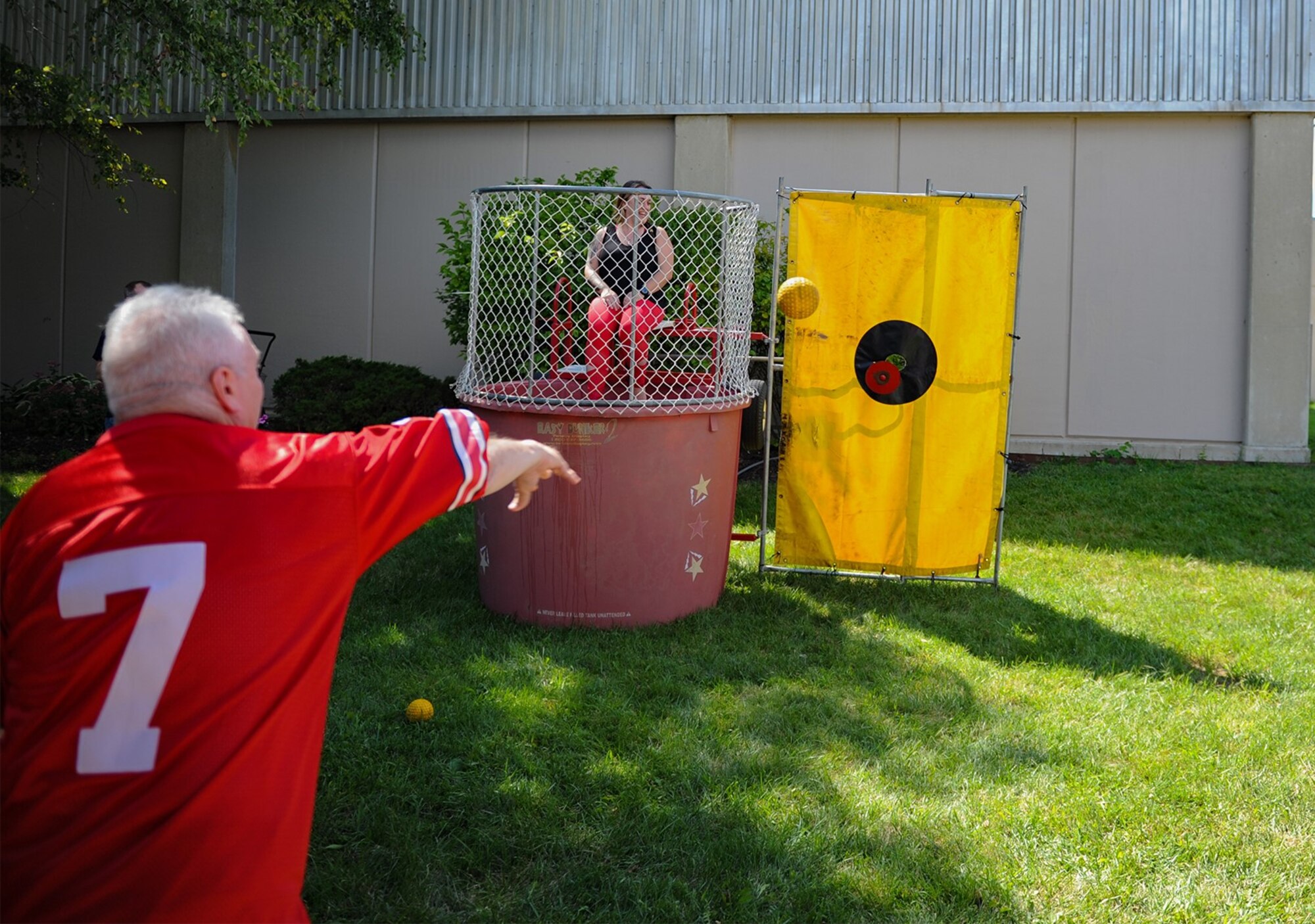 Rob Young, National Air and Space Intelligence Center throws a ball aimed directly at the target of the dunk tank during the National Air and Space Intelligence Center block party at Wright-Patterson AFB, Ohio, Sept. 8, 2022. The dunk tank served as a fundraiser to raise proceeds for the NASIC Ball.